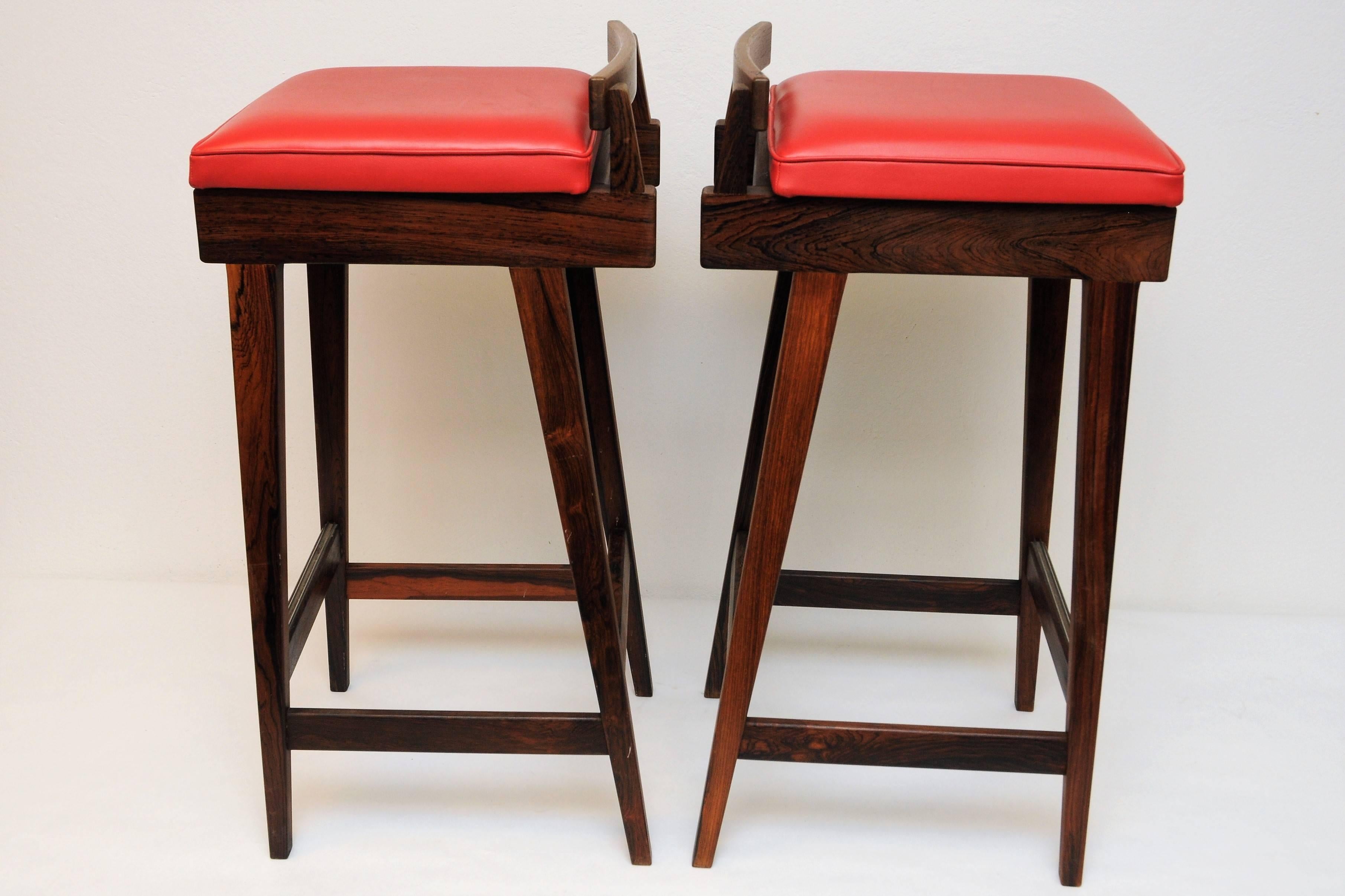 These three rosewood barstools were designed by Knud Bent and produced by Dyrlund, Denmark circa in the 1970s. They feature red upholstery.
