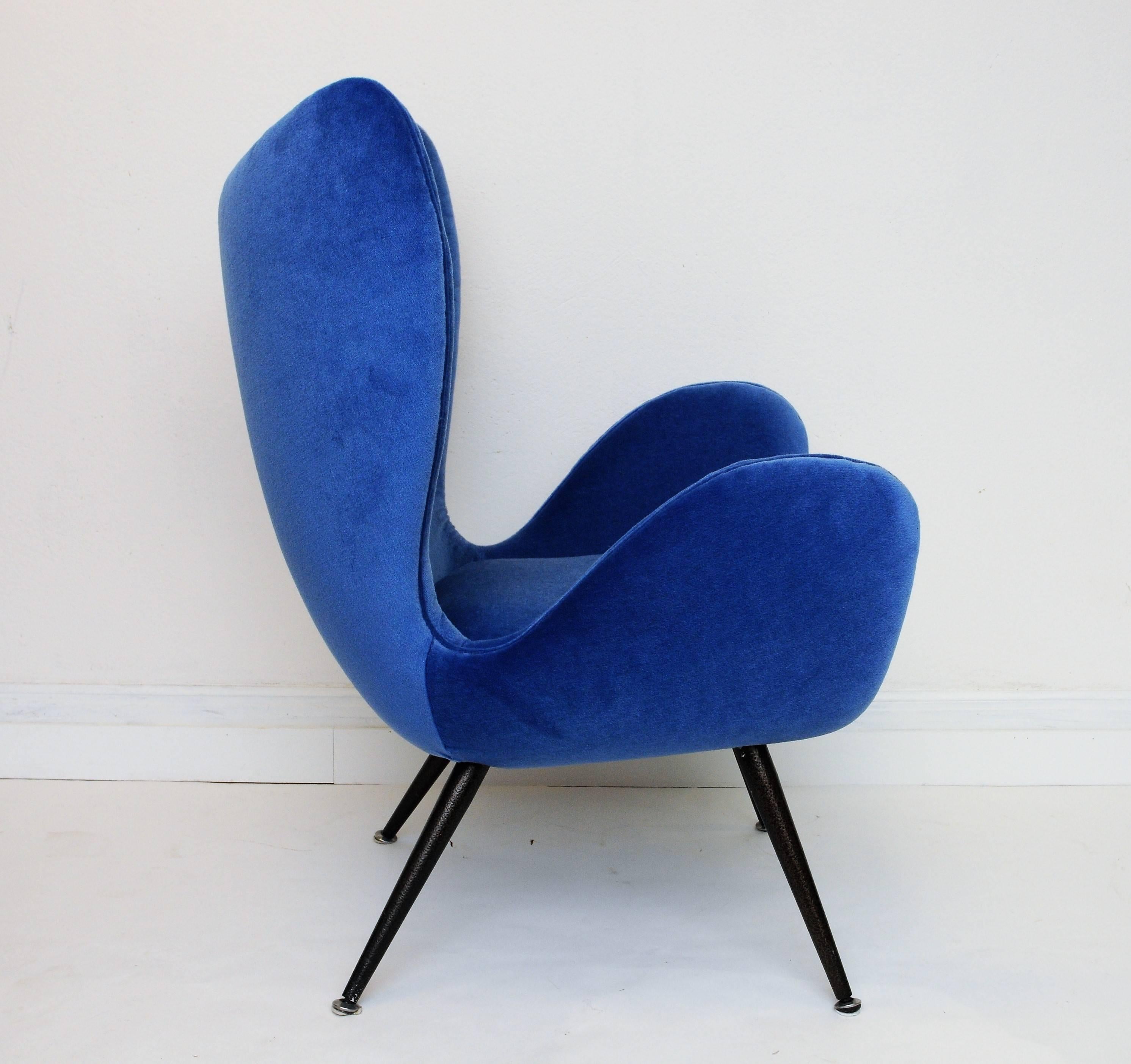 This pair of blue velvet armchairs has been newly upholstered and features metal drumstick legs in black color. With their quite so unusal form they might look like 