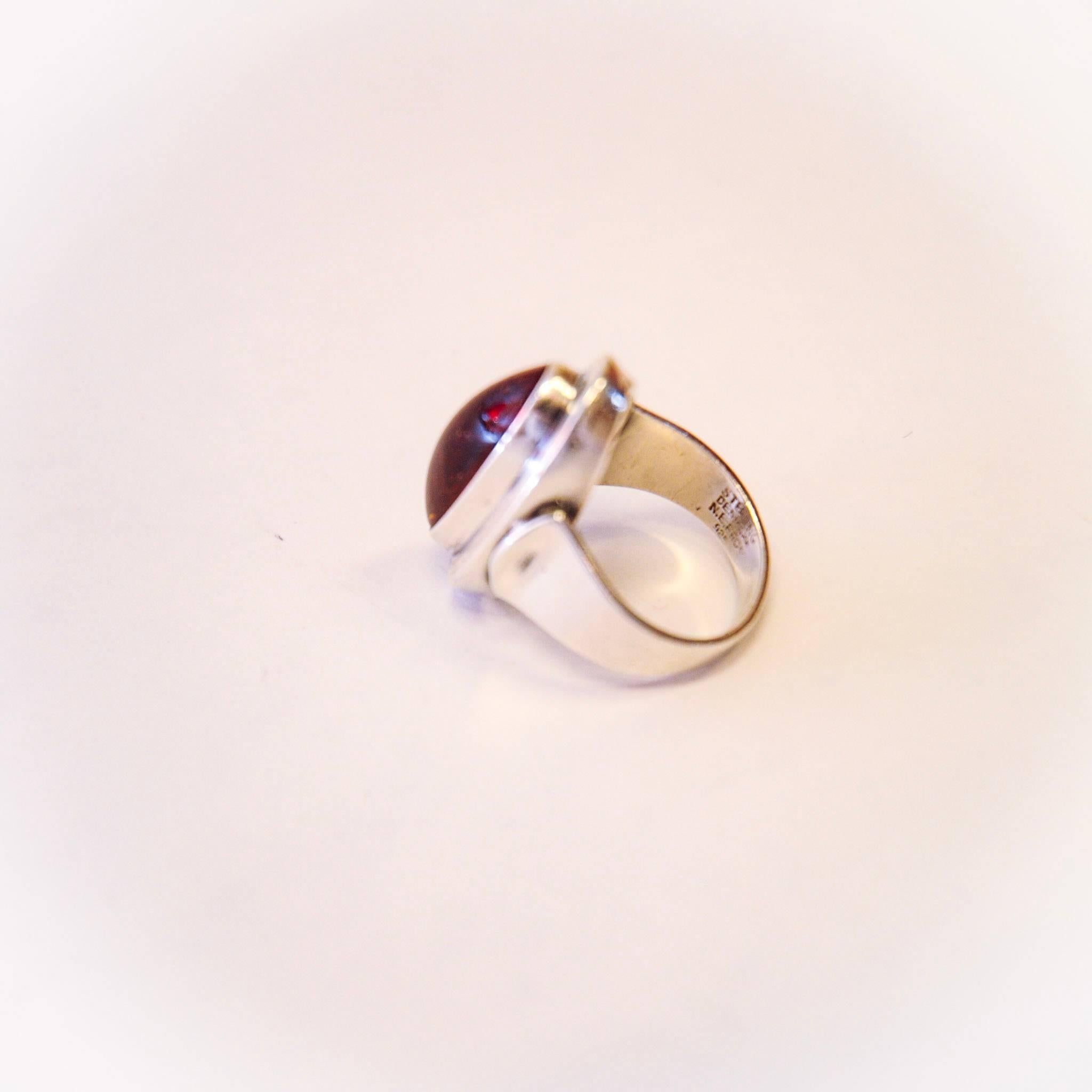 Attractive sterling silver ring with amber from the last midcentury, made by Nils Erik from, Denmark. (Nakskov, 1944-2009). Stamped. Sterling, Denmark, 925S & N. E. From. Size 52 mm. Perfect vintage condition.
 
