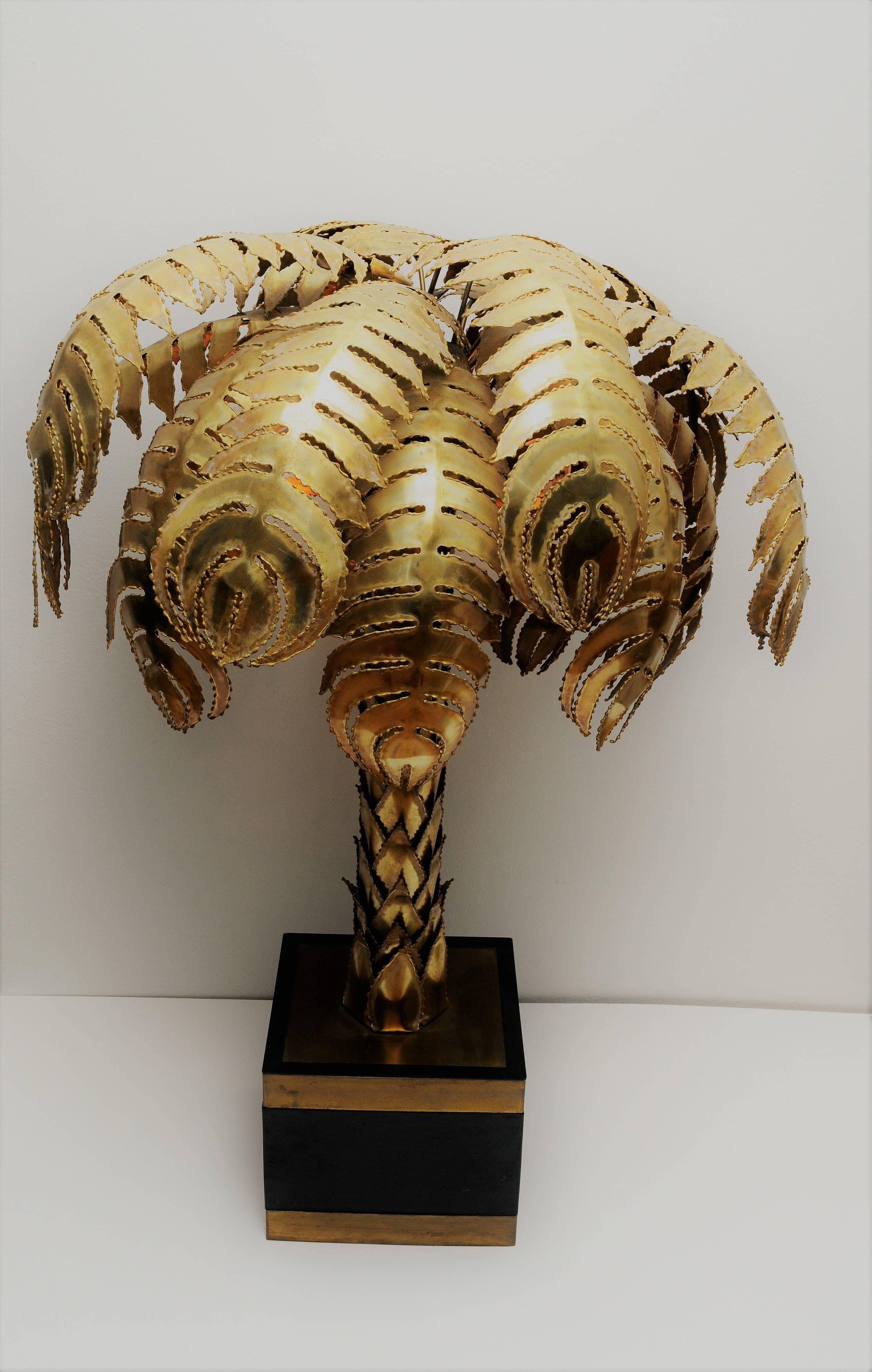 This golden palm tree lamp dates from the 1960s and was made by Maison Jansen. It requires two bulbs, has a brass and black ABS base.

Maison Jansen (House of Jansen) was a Paris-based interior decoration office founded in 1880 by Dutch-born