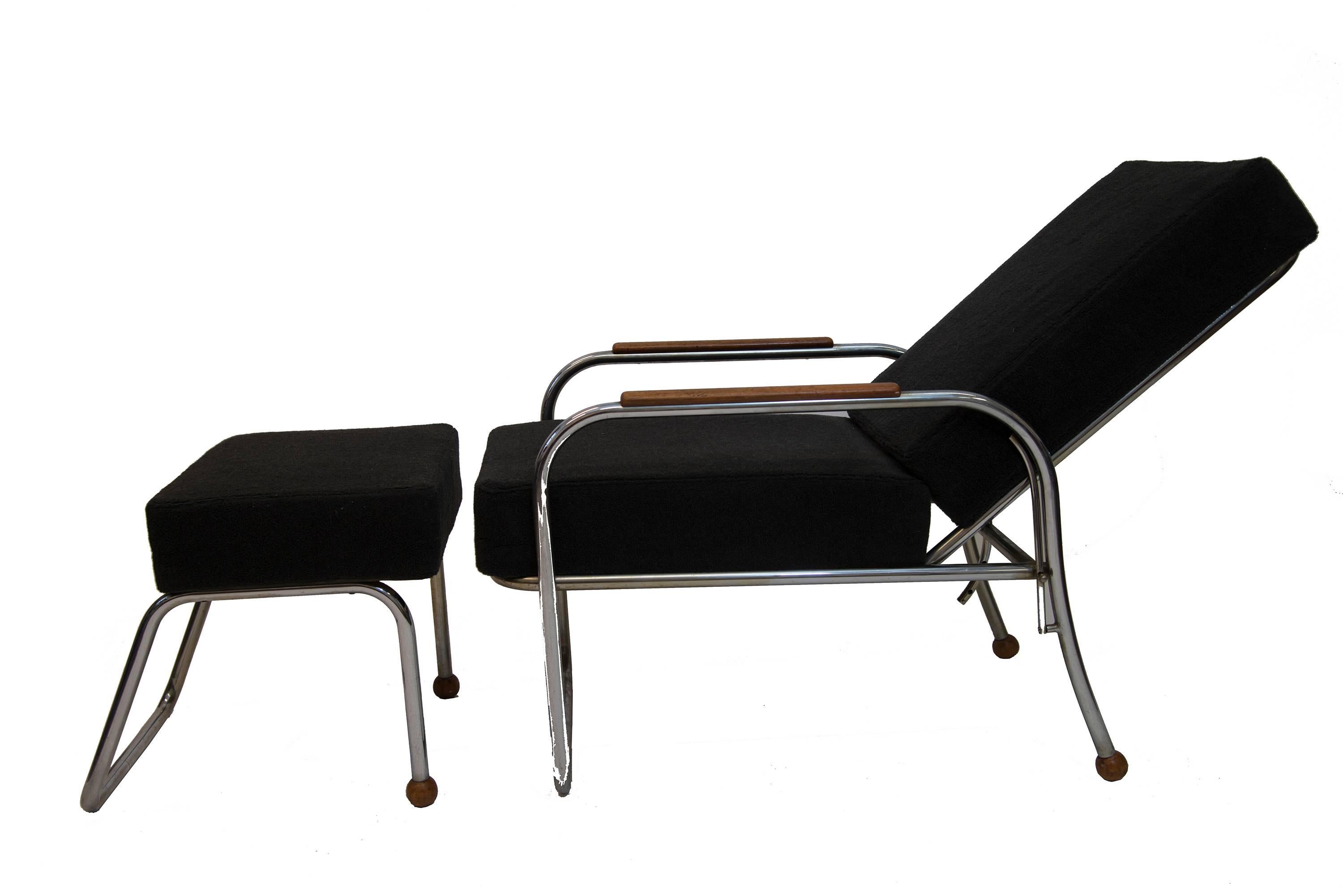 Nice design funkies armchair with footstool in Bauhaus style. With metal legs and teak armlayers. Also teak on back legs of both chair and footstool formed as small balls. Nice black/grey cottonlike soft fabric. From circa 1930s. Adjustable back in