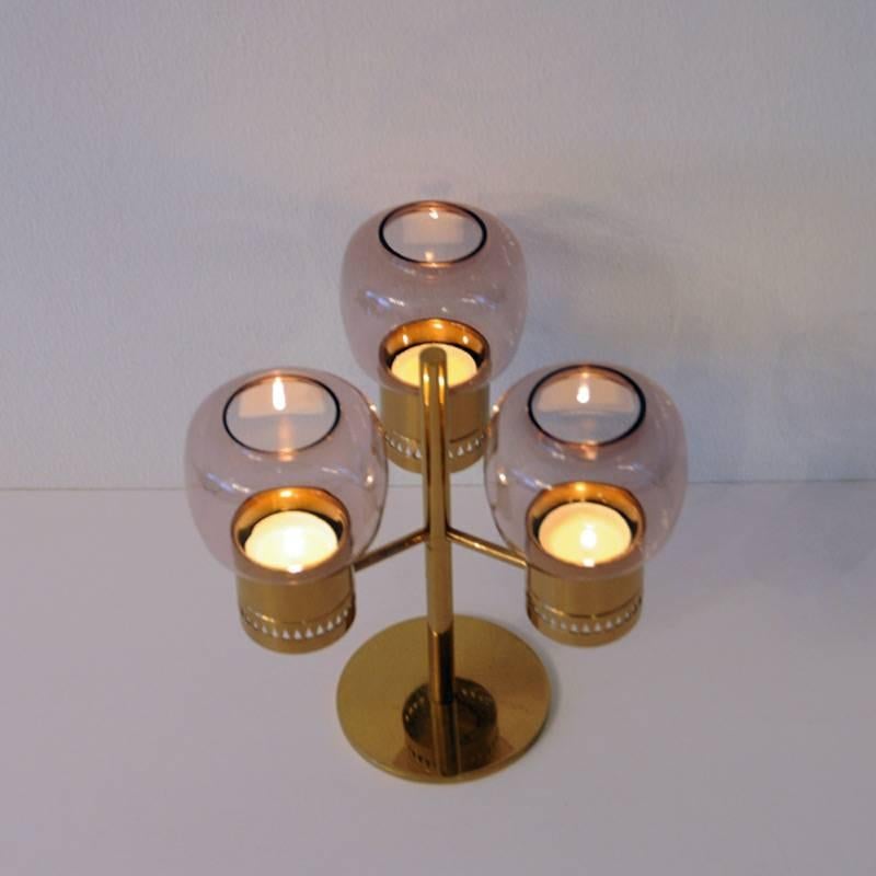 Brass and glass candleholder set with three purple glassdomes model L67 designed by Hans-Agne Jakobsson, Markaryd, Sweden. From circa 1950s, for tealights. 

Hans-Agne Jakobsson (1919-2009) was a Swedish interior decorator and furniture designer