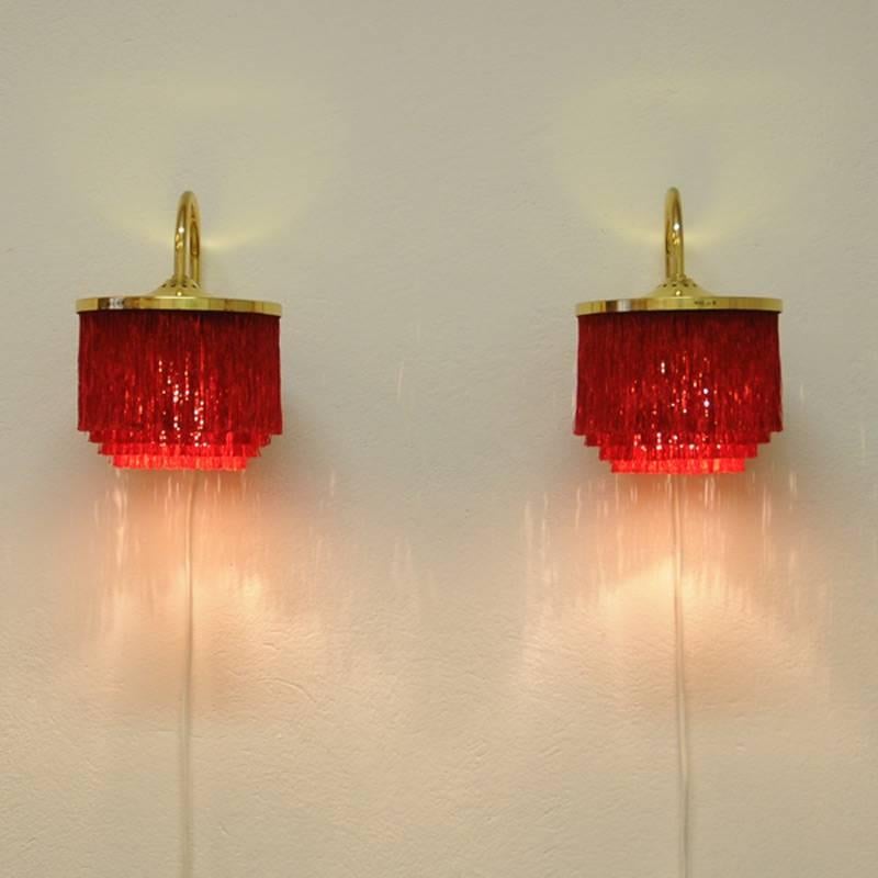 Pair of  beautiful wall lamps model V271 of brass and red silk fringes designed and made by Hans-Agne Jakobsson, Markaryd, Sweden. The Fringe lamp has from being quite an original lamp some years ago years turned into being a very popular and