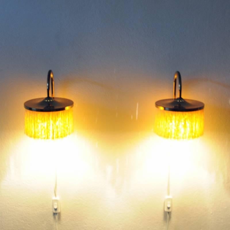 Pair of wall lamps model V271 of brass and yellow silk fringes are designed and made by Hans-Agne Jakobsson, Markaryd, Sweden. The Frans lamp has from being quite an original lamp some years ago years turned into being a very popular lamp all over