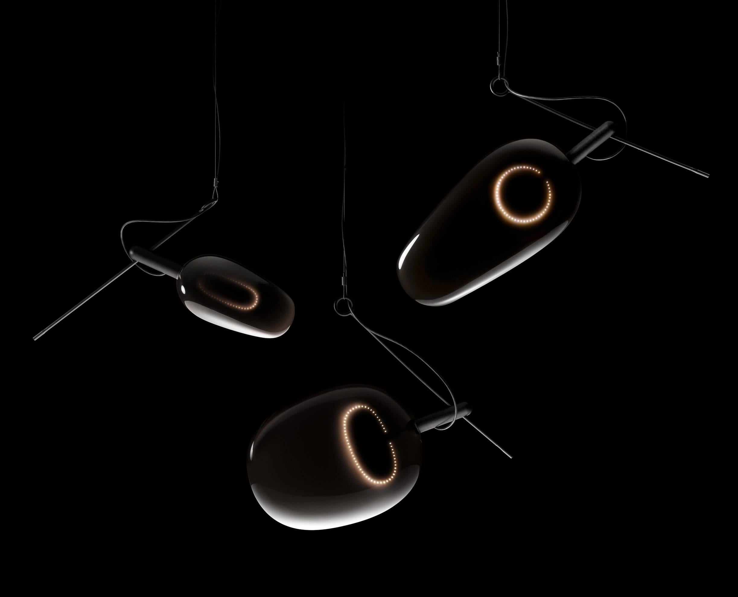 Amber is a pendant lamp in which a LED circuit board is embedded in colored resin. The color of light, reminiscent of a gentle flame, melts into the surrounding black creating a smooth gradation.