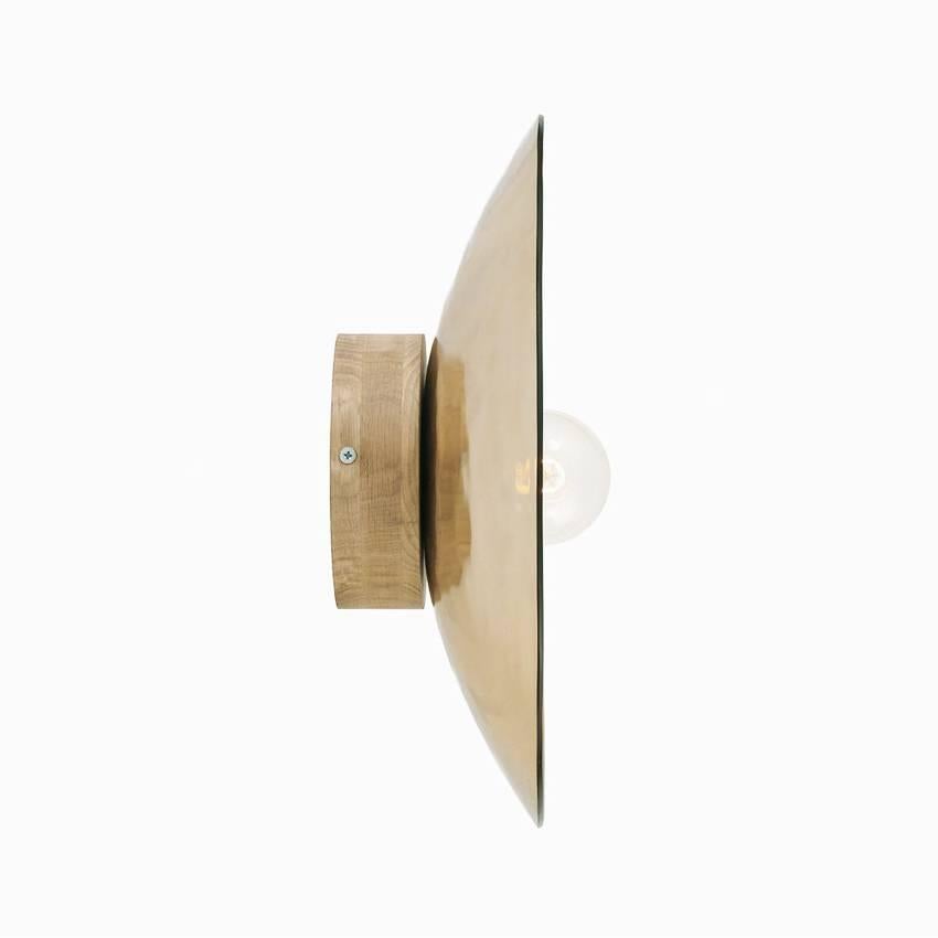 Gold thermoformed glass (also available in silver) mounted on a base available in lacquered black metal or solid oak.
Can be used as a wall or ceiling light.
Handmade in Europe 

Available in three sizes :
Large 27.6 in diameter x 5.9 in