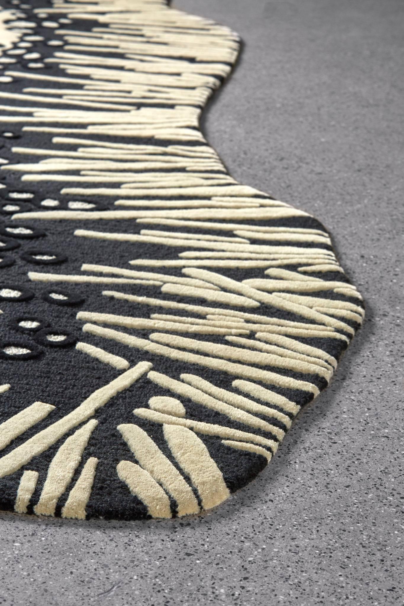 Inspired by a majestic volcano in Costa Rica, the Arenal area rug by Angela Adams celebrates a sense of exploration. Rocks and crystals line the crater's edge in dramatic black and white. Hand-carved, tufted and sculpted in 100% pure New Zealand
