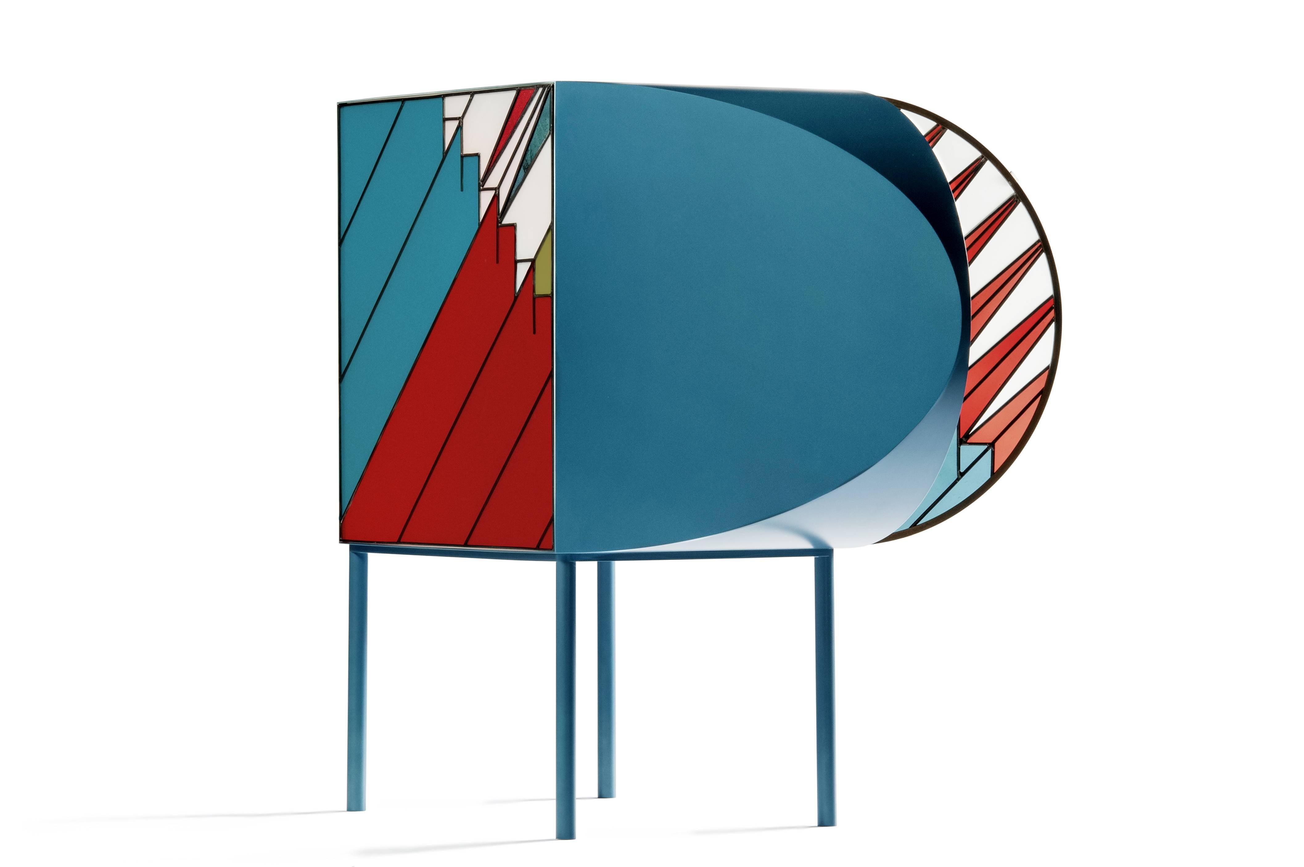 Sideboard produced in lacquered metal and stained glass. The pattern recalls a pyramid under the sun, where the “spines” are rays of light.
The sideboard is part a capsule collection inspired by the windows of holy sites as the ones created by