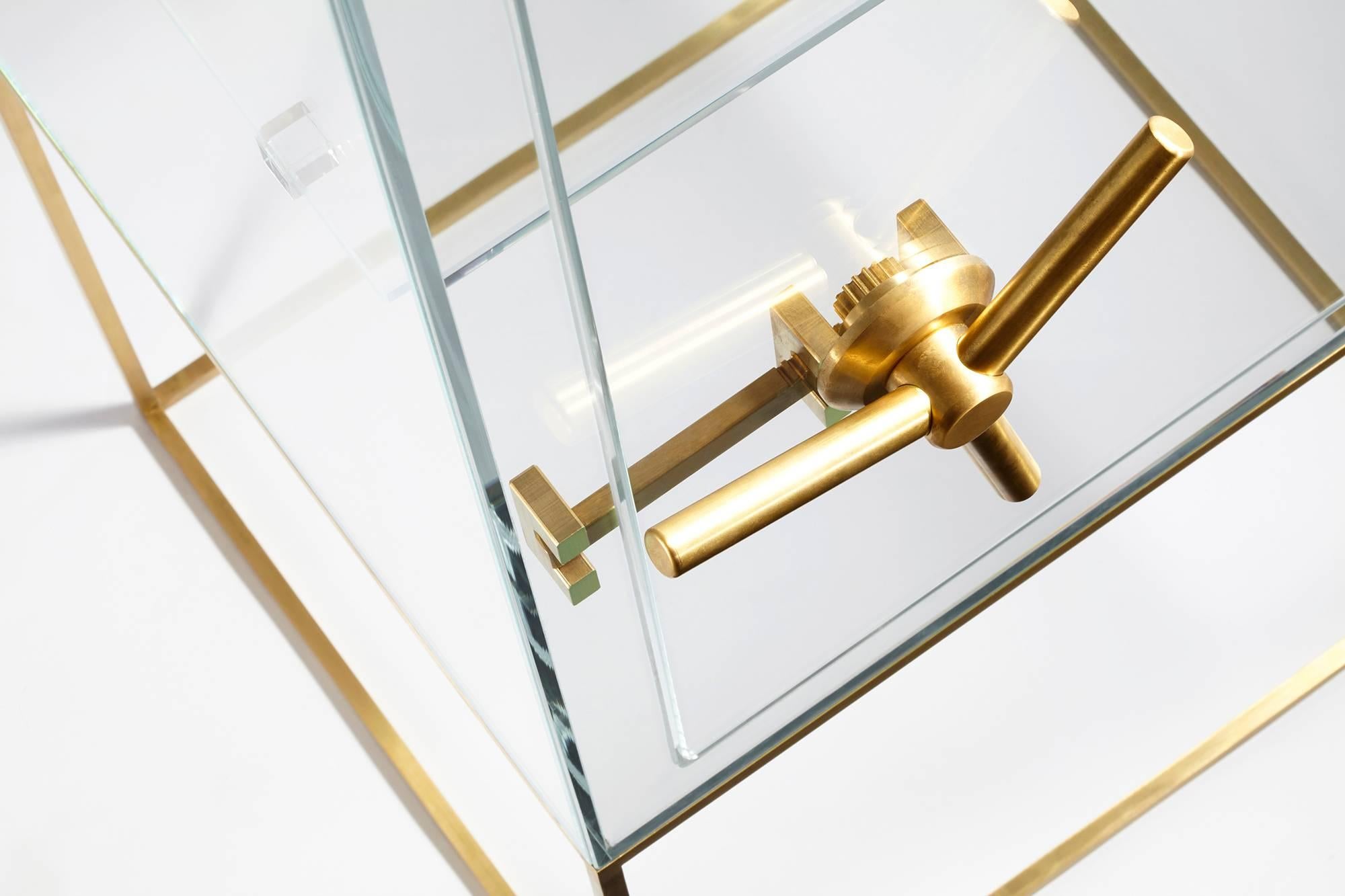 Storage furniture in transparent extra-light crystal with mechanism and base in brushed brass. 
As a real safe, it protects the content revealing the essence. 
A symbolic up-to-date object where everyone is free to decide what is worth