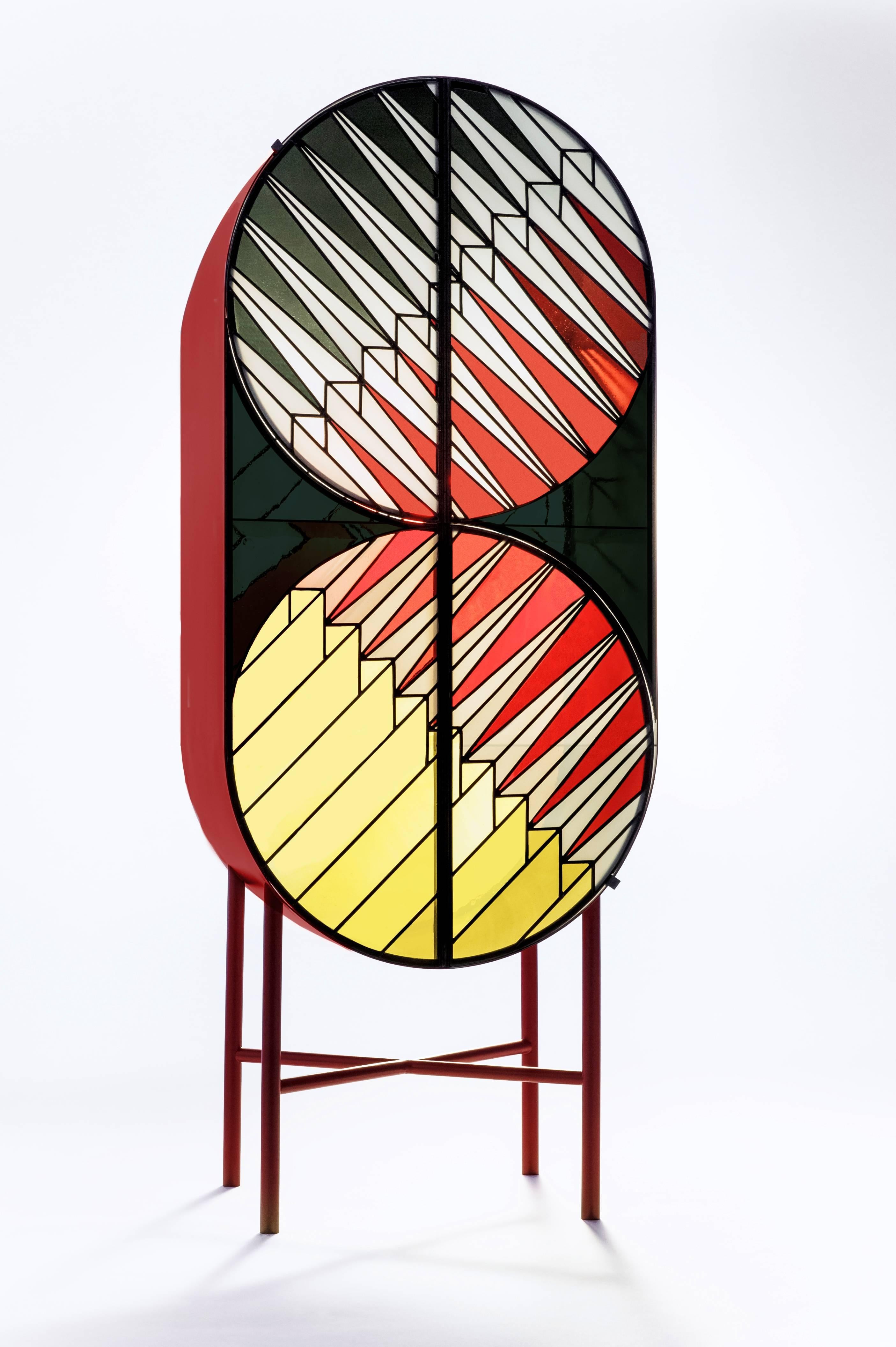 Cabinet produced in lacquered metal and stained glass. The pattern recalls a pyramid under the sun, where the “spines” are rays of light.
The cabinet is part a capsule collection inspired by the windows of holy sites as the ones created by Gerhard