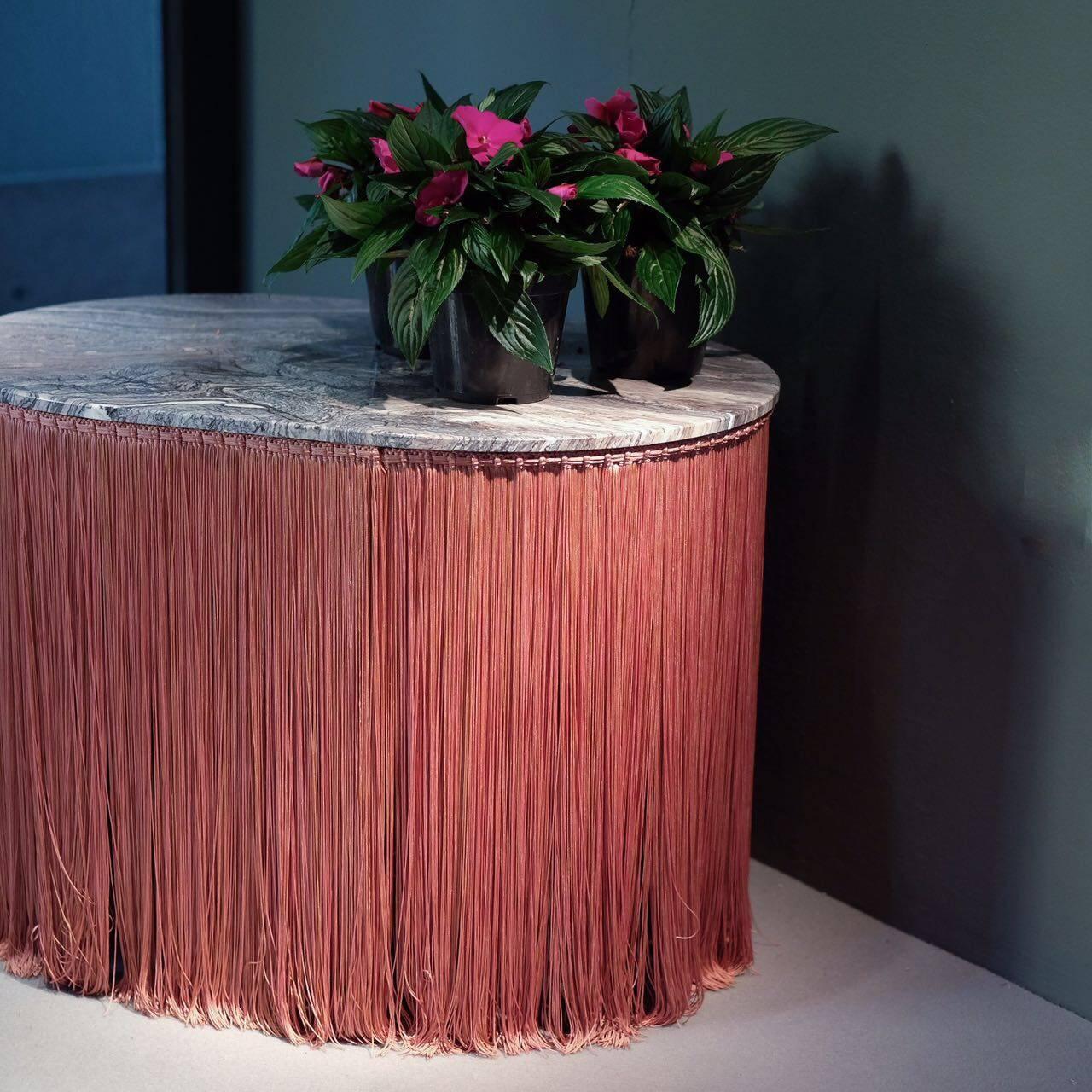 Low table in Red Cipollino marble with coordinated fringes. 
Tripolino plays with the iconic element of passementerie usually used as a decorative element of bourgeois lounges.
Applied to the edges of the table, it looks as fringes are sustaining