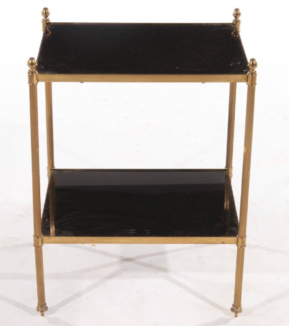 A French bronze side table in the style of Maison Jansen with black glass top and shelf supported on reeded legs.