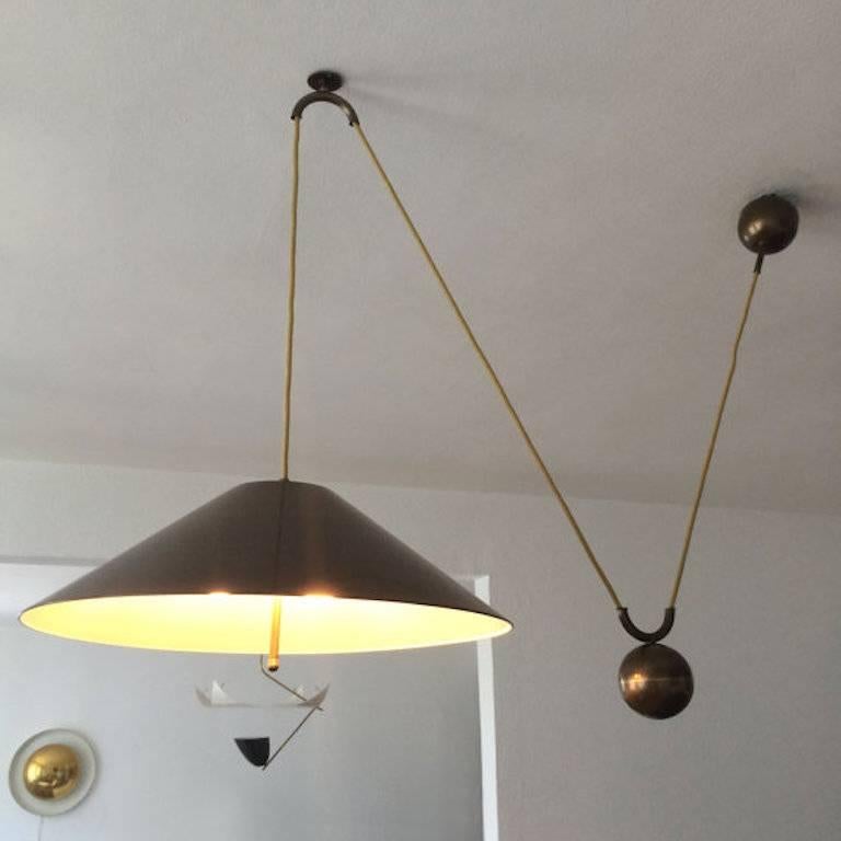 Large pendant lamp designed and manufactured by WKR Leuchten GmbH in Germany in the style of Florian Schultz. Features a brass shade with a white lacquered interior and a heavy counterweight providing an adjustable height. 

The pendant measures