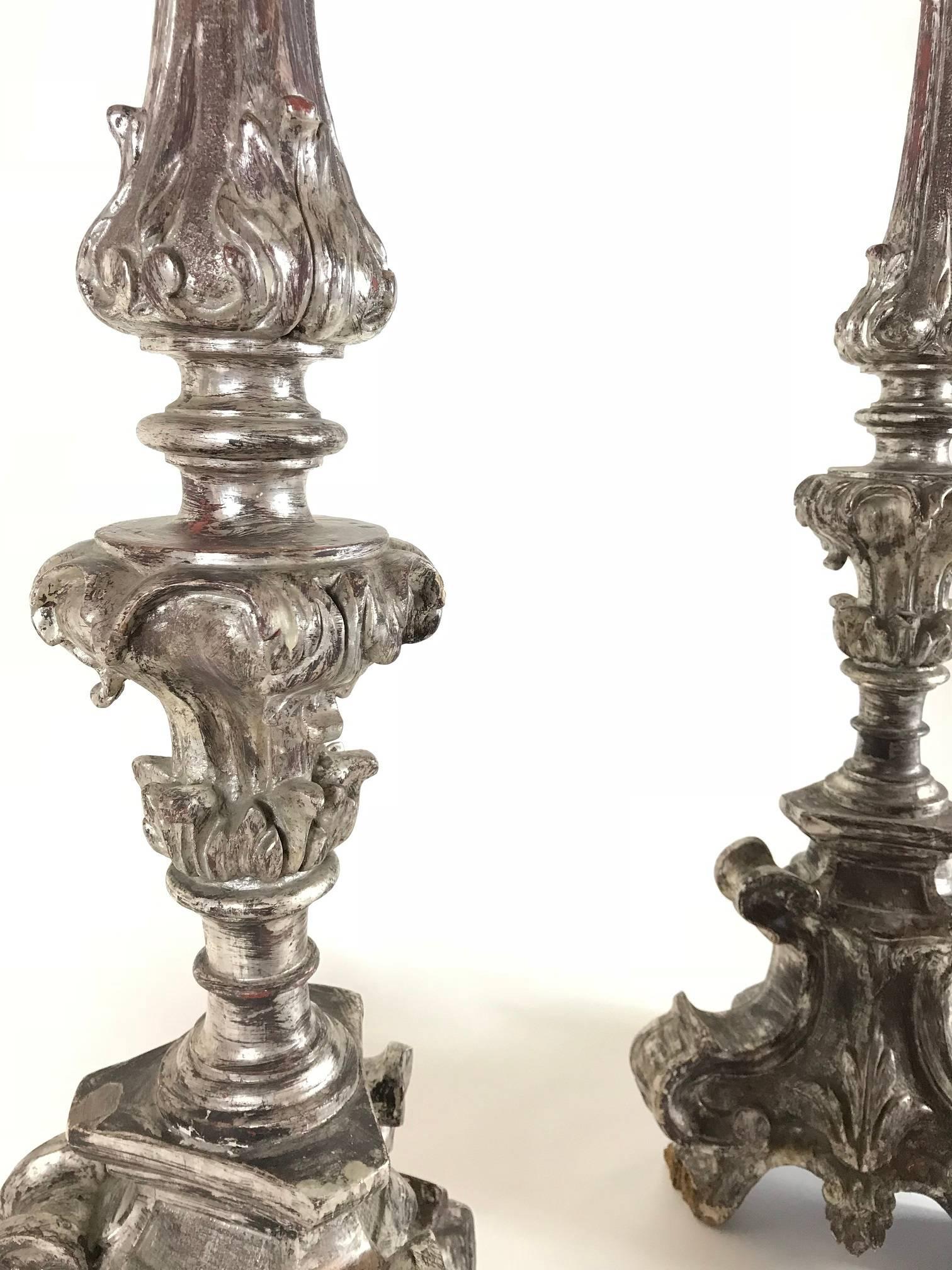 Pair of finest hand-carved Italian silver gilt candlesticks from late 17th century. 
These rare altar prickets are handmade in the Italian Baroque era -  they feature elaborate palmettes, shields, acanthus leaves and a tripod base with scrolled