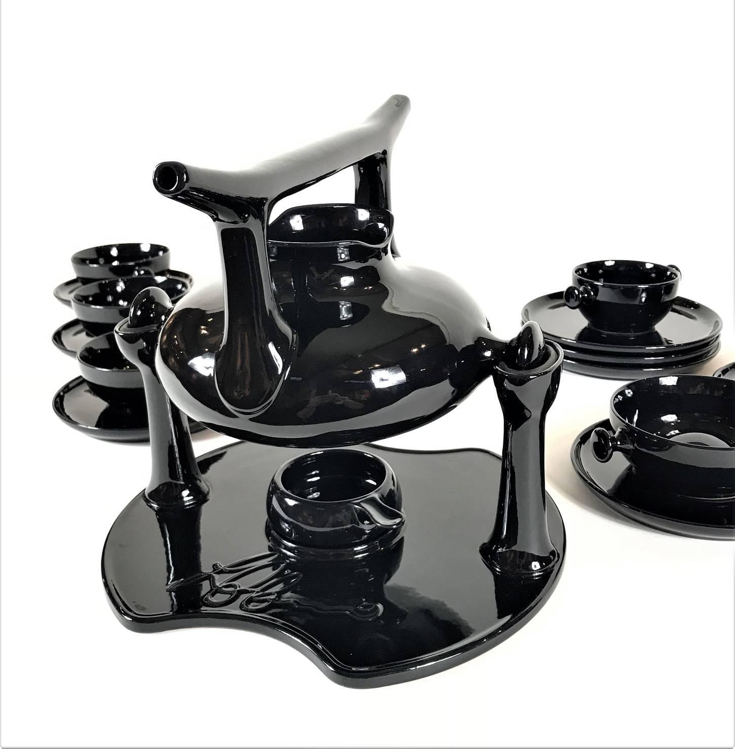 A 1973 complete tea set designed by Luigi Colani for Friesland, Germany. This Ceracron earthenware tea set is black glazed. The set consists of: Tea pot, warming stand, six cups and plates, six dessert plates, tea light holder, milk and sugar bowl.