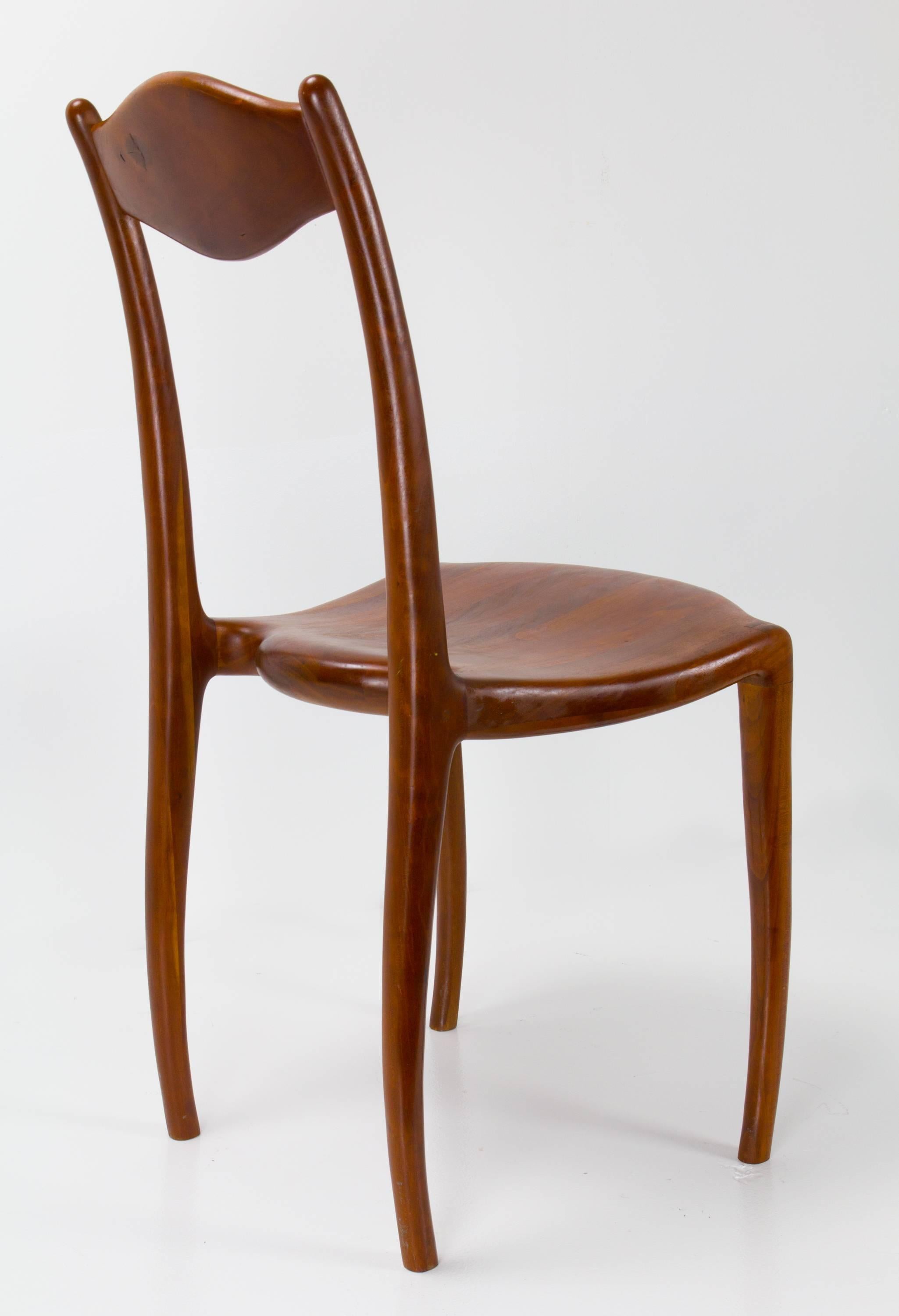 American studio craft movement chair in solid cherry by Stewart Paul with whimsical construction detail including inward bending carved legs.