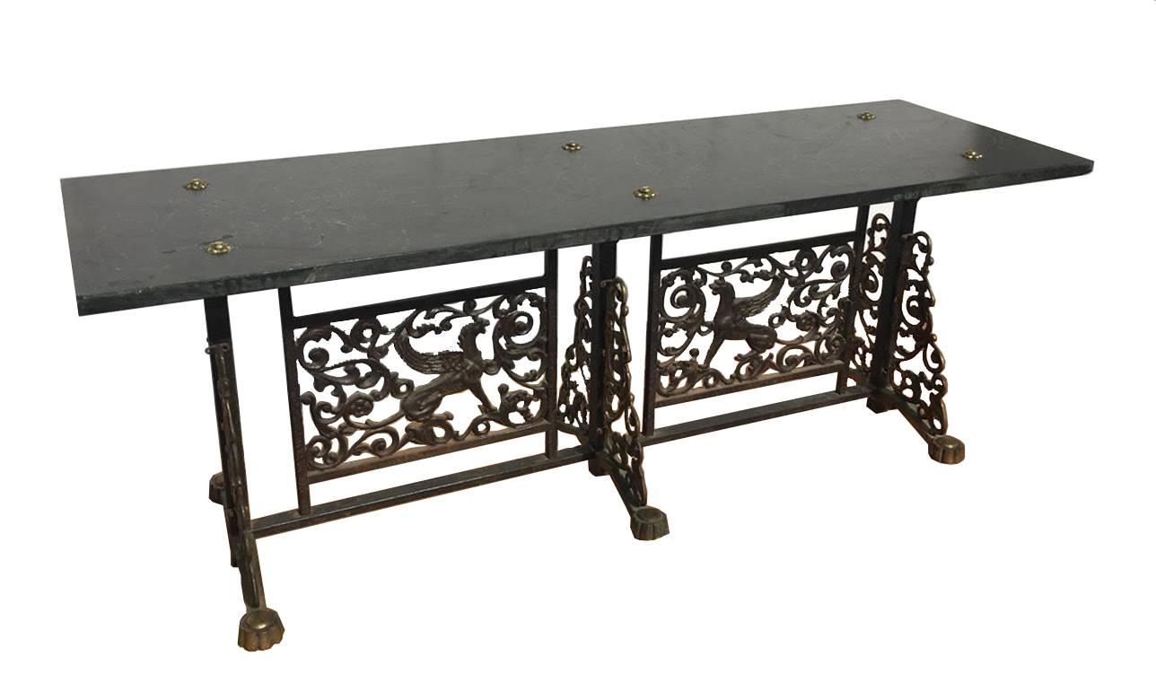 A very good Oscar Bach style bronze and iron bench having slate seat over Art Deco griffin panels framed by trellis decoration, circa 1910. All raised on bronze and wrought iron base measure: Height 16