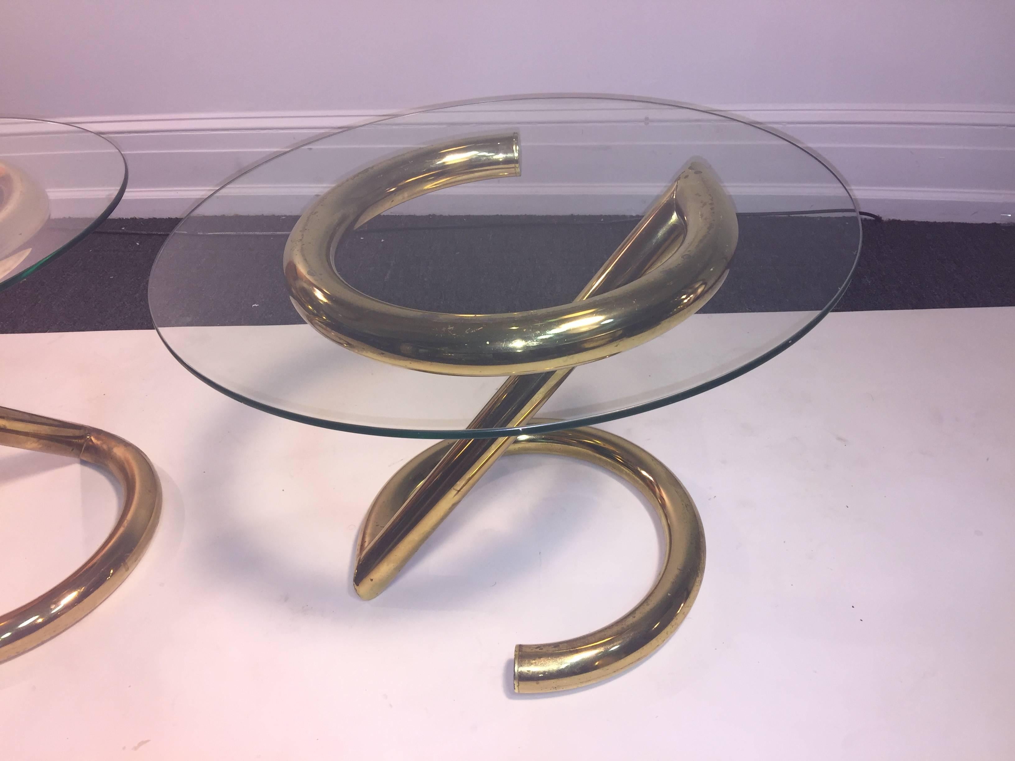 Modernist Pair of Polished Goldtone Metal Tables With Tubular Modern Design Bases and round glass tops.