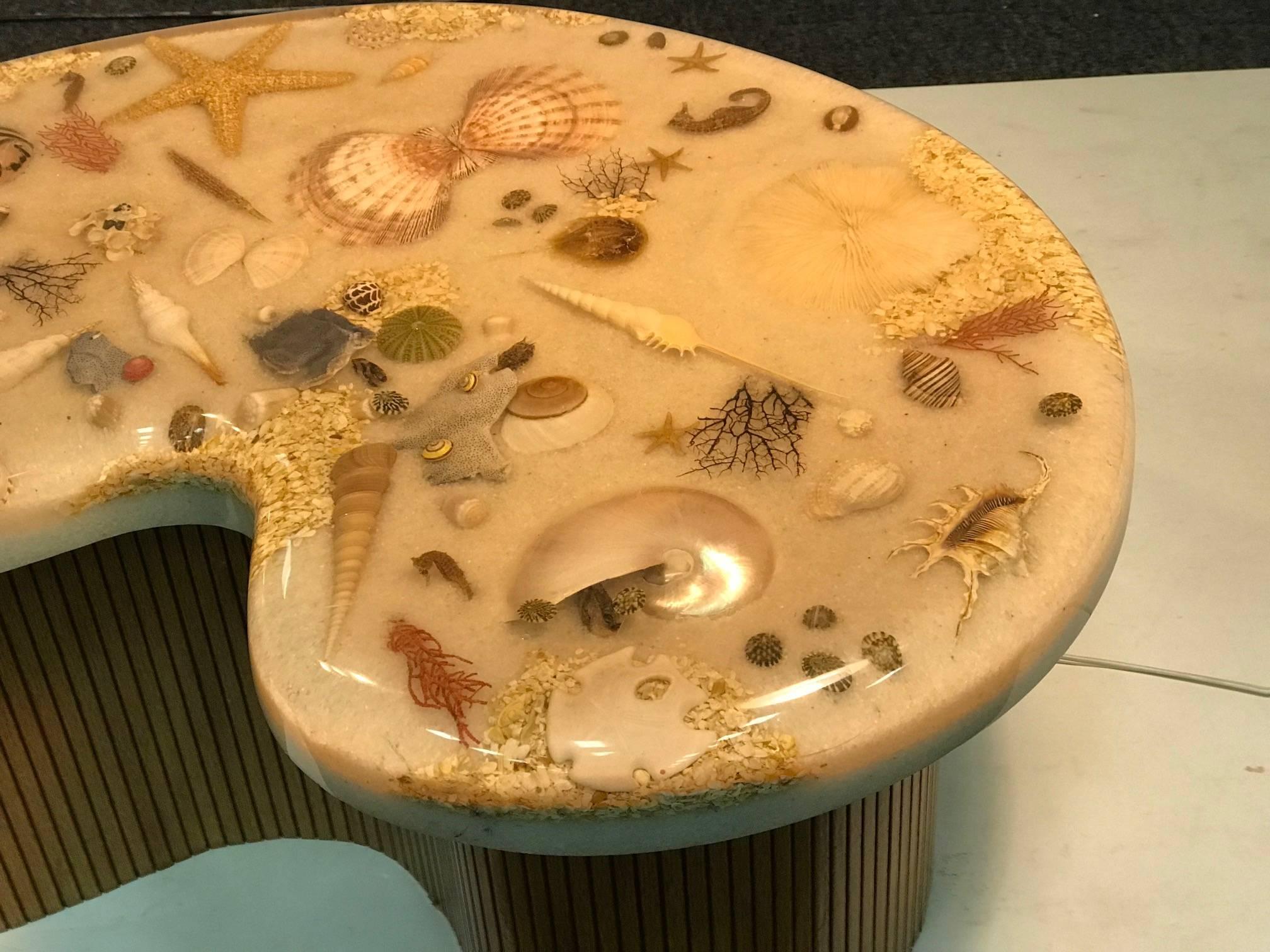 Unique Exotic Sea Shells ,Various Starfish and Other Sea Creatures With Sand Encased in A Biomorphic Resin top on Blonde Wood Slatted Base Coffee Table. Designed Circa 1990's By Joe Twombly.