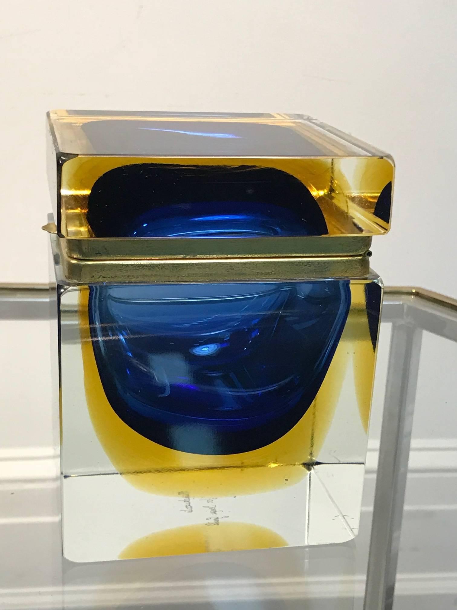 The colors of navy/royal blue to amber yellow make this Italian glass midcentury beautiful Sommerso box a show stopper. It has brass by the hinged top. It is very heavy and deep; signed on the bottom Mandruzzato.
