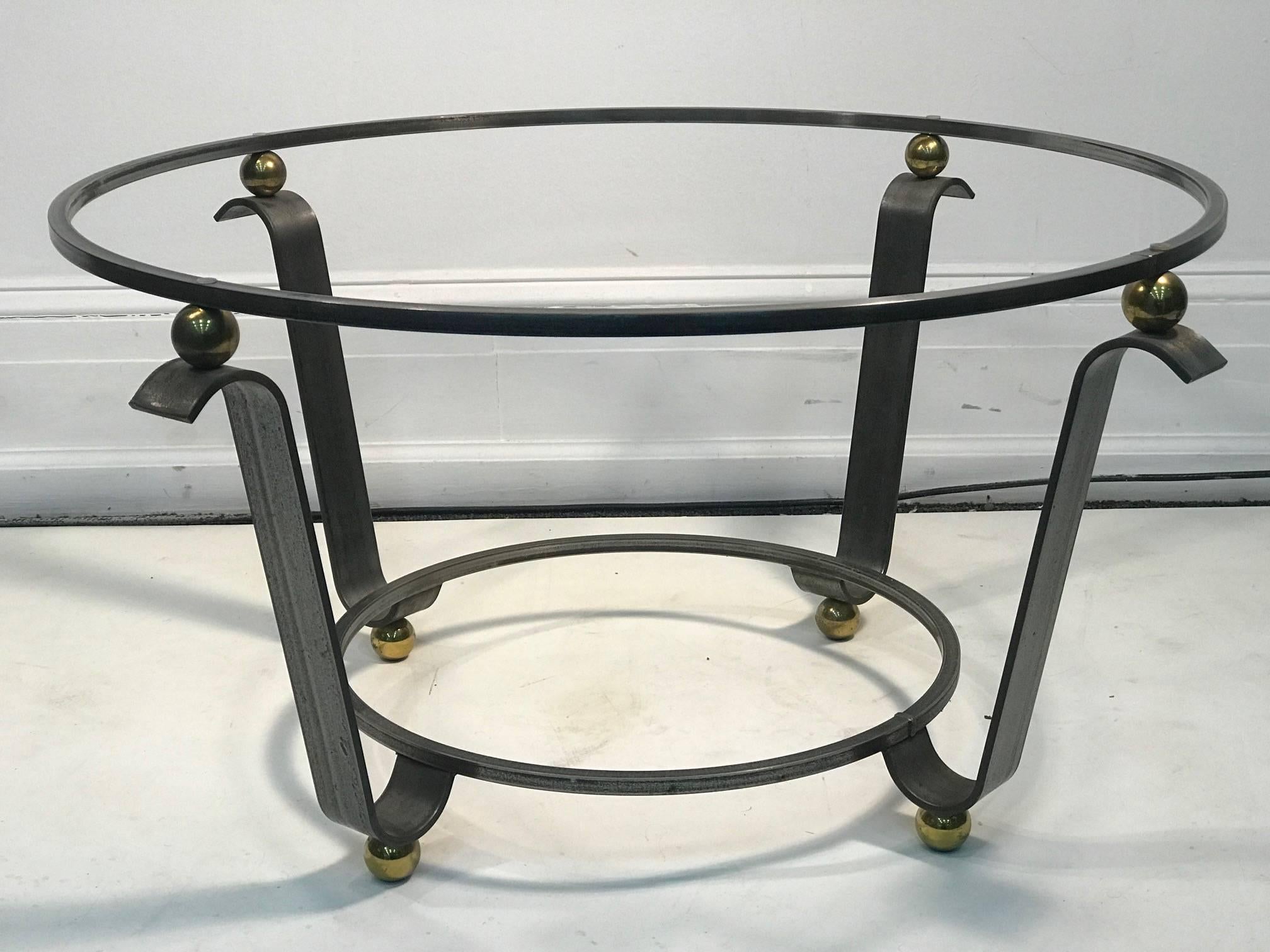 Art Deco coffee table or accent table glass top in the style deco
Iron frame and brass balls.
 