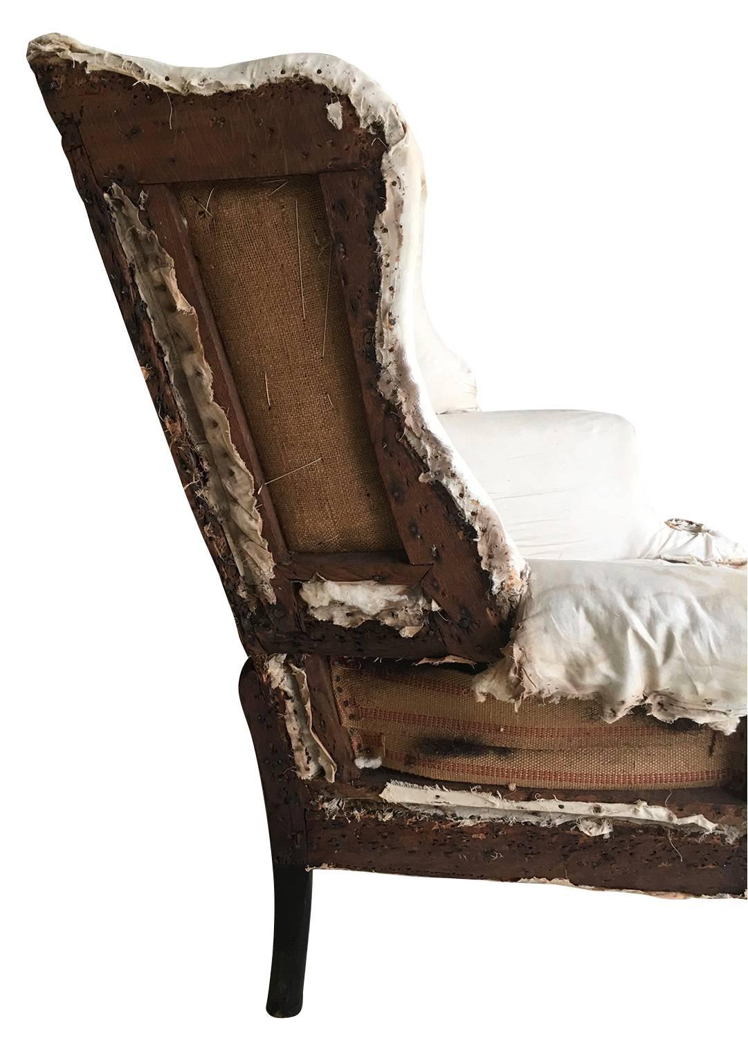 Philadelphia Chippendale carved mahogany easy chair, 1760-1780, having a canted back with slightly serpentine cresting, scroll wings, and upright outward scrolling arms, above a seat with loose cushion over cabriolet legs with ball and claw