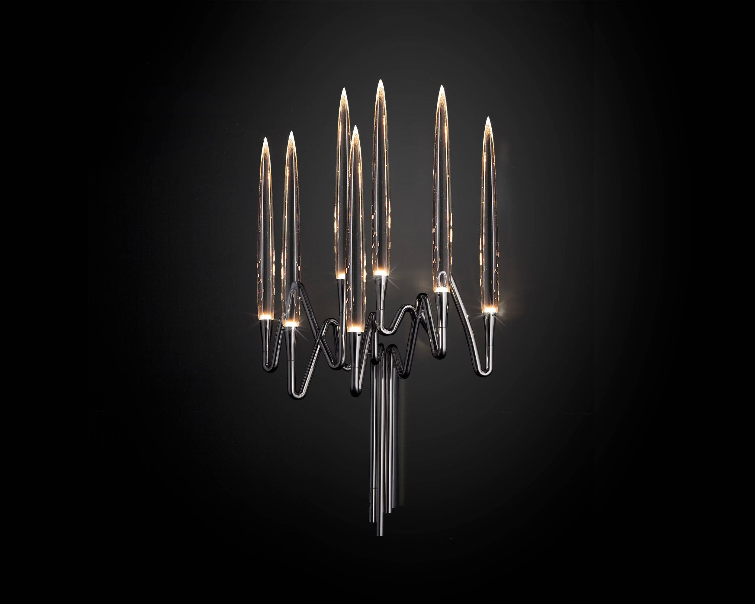 Inspired by Arabic calligraphic art and the icon of the classical candelabrum is Il Pezzo 3 Wall Sconce, with a hand-forged brass structure and elegant “candles” crafted from solid crystal.
The candles are illuminated using the latest LED
