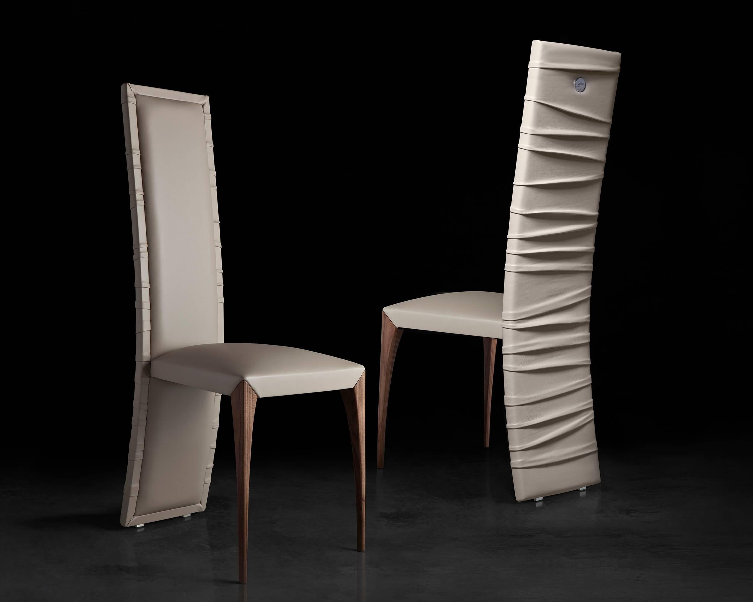 Sinuous folds envelop the elegant structure of Il Pezzo 7 Chair. Expertly upholstered in high- quality leather or velvet by master craftsmen, it boasts a rich, soft backrest, wrapped in its graceful folds. The seat features a solid wood base with a