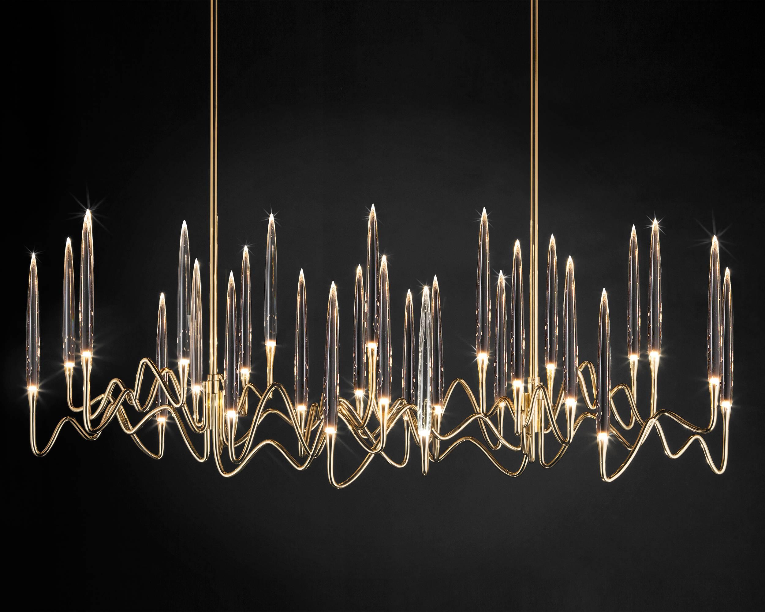 Inspired by Arabic calligraphic art and the icon of the classical candelabrum is Il Pezzo 3, a collection of lamps with a hand-forged brass structure and elegant “candles” crafted from hand blown crystal, according to the noble Tuscan artisan