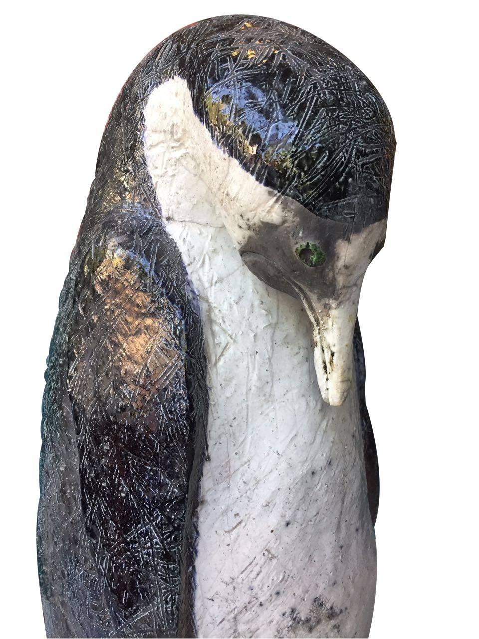 Beautiful penguin sculpture with irregular enamel finish, almost covered in black and white, green eyes. Presents a crack in the lower part (part of the creation process). Anonymous.