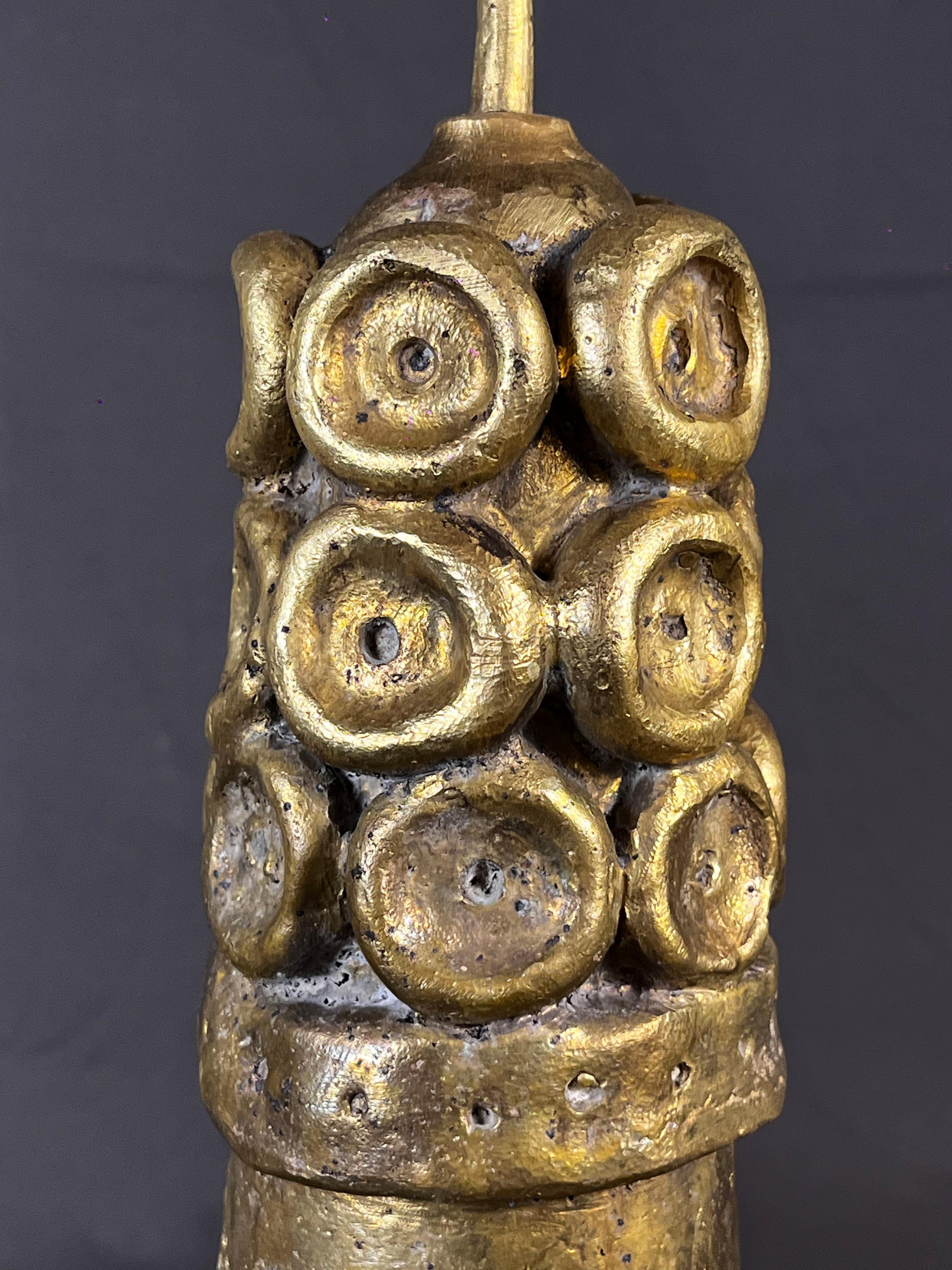 Pesado candelabro escultórico de bronce fundido, obra del escultor francés Eric Ledoux. El candelabro muestra un sol en la parte delantera y una luna creciente en la trasera. La parte superior y los brazos están decorados con medallones. El bronce