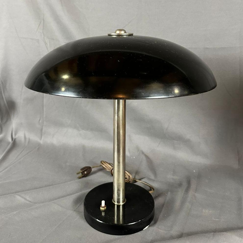 Lámpara de escritorio alemana en forma de seta de la Bauhaus de 1930. Modelo 6563 de Christian Dell fabricado por Kaiser Idell. La pantalla de la lámpara está esmaltada en negro y tiene forma de seta que engloba la fuente de luz. Viene con el