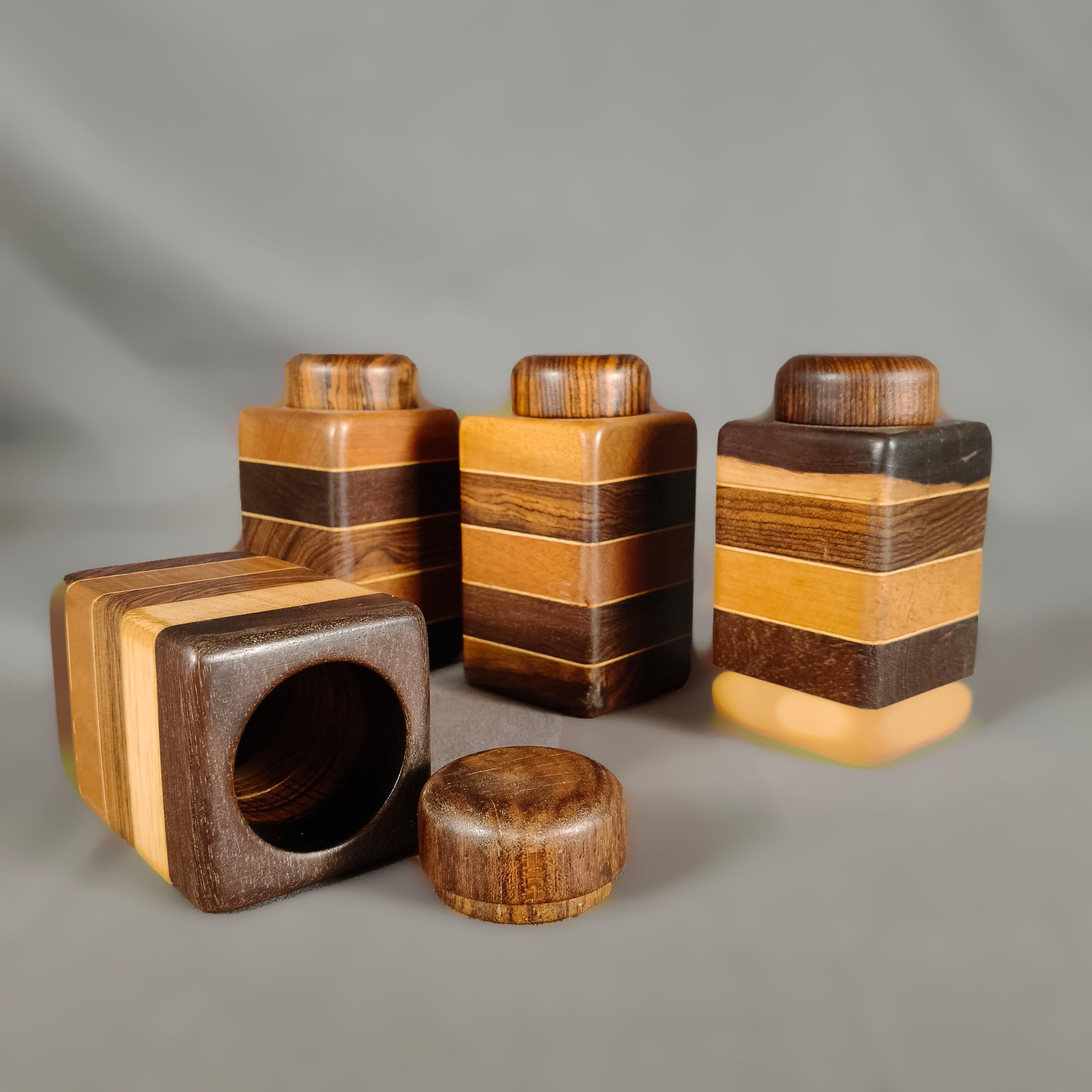 A 1970's Mexican mixed hardwood set of 4 spice boxes by American designer Don S. Shoemaker. The geometric shaped boxes with round covers are designed with bands of different woods. 

Don S. Shoemaker (1917 - 1990) is one of the most important