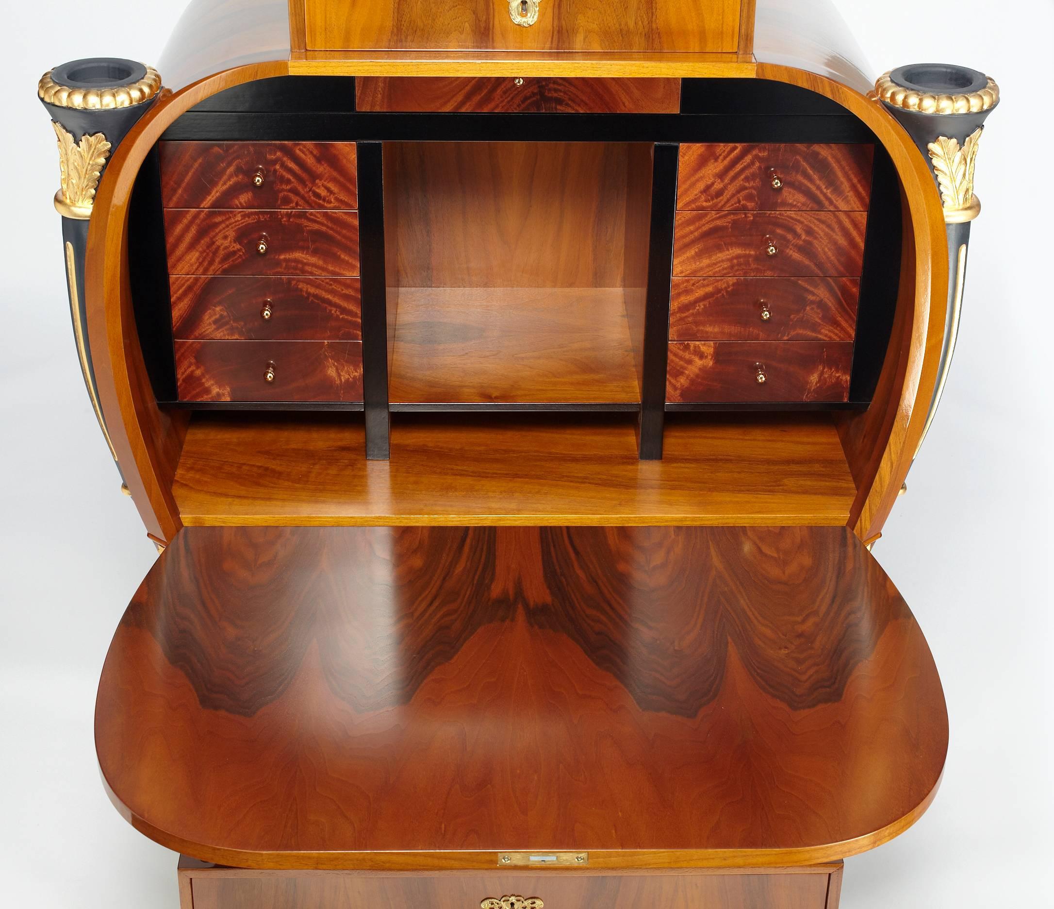 A classic of Biedermeier design, this large Secretary consists of drawers and an integrated fold down writing desk. Curved body and a stepped drawer unit on top containing three drawers, with carved and gilded chimeras. At the bottom three curved