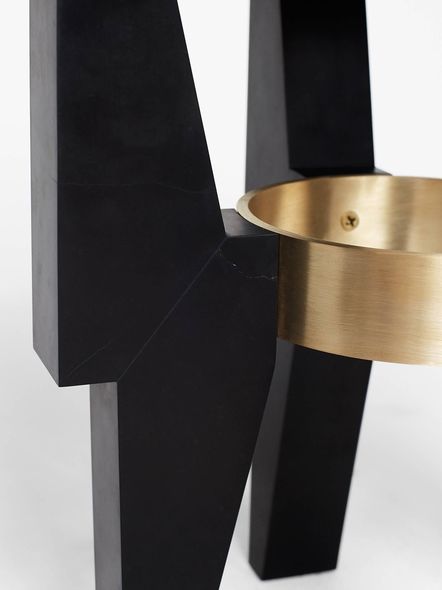 Hand sculpted by Los-Angeles based master stone carver, Nathan Hunt, the High Ring Side Table is made entirely from Nero Marquina marble and is complimented by a brass ring which ties each leg of the coffee table together.

Perfect as a side table
