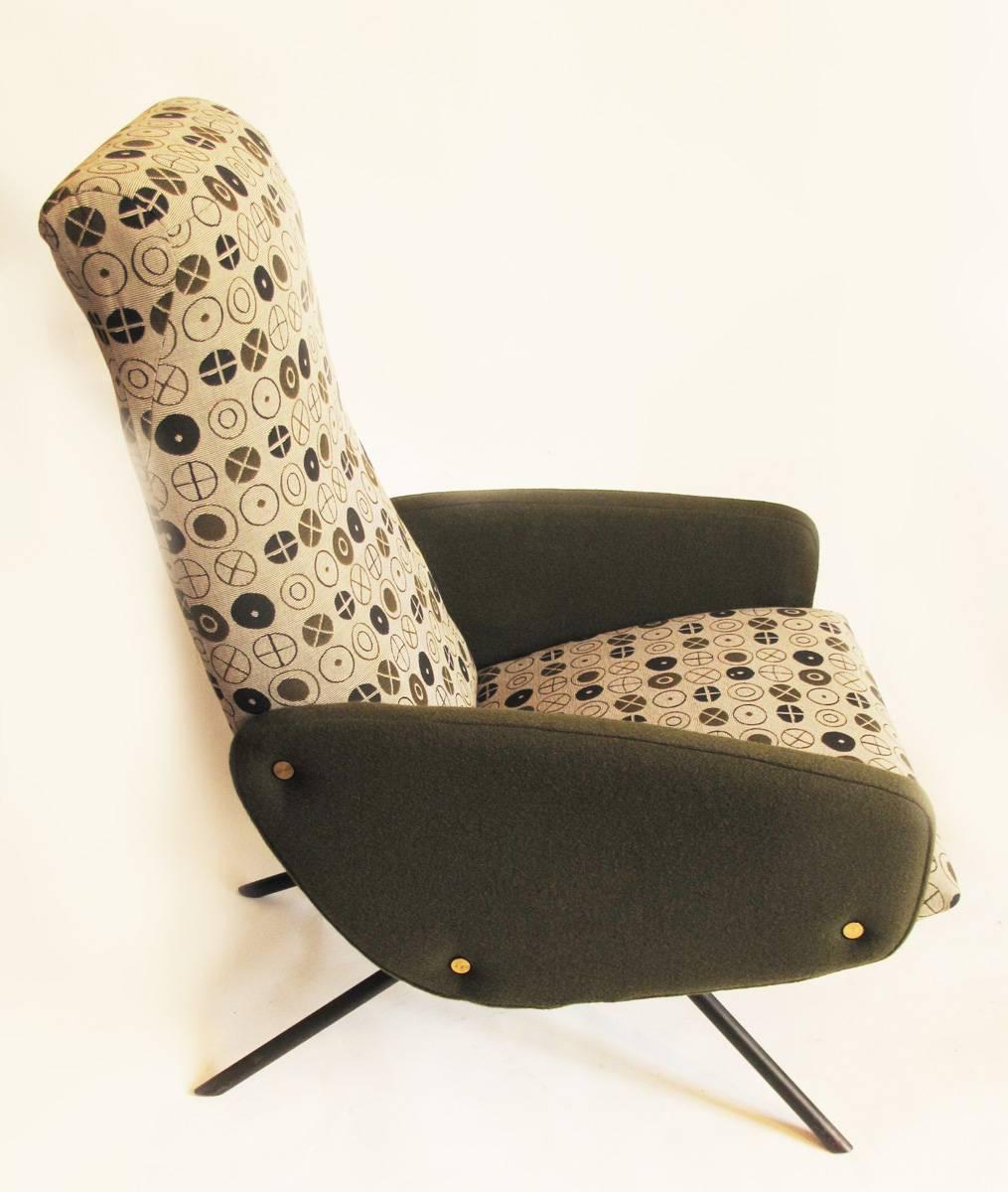 This armchair was designed during the 1950s and produced in France.

It features an iron structure under the fabric ending in four black iron legs that start in the middle of the seat and expand to de sides like 