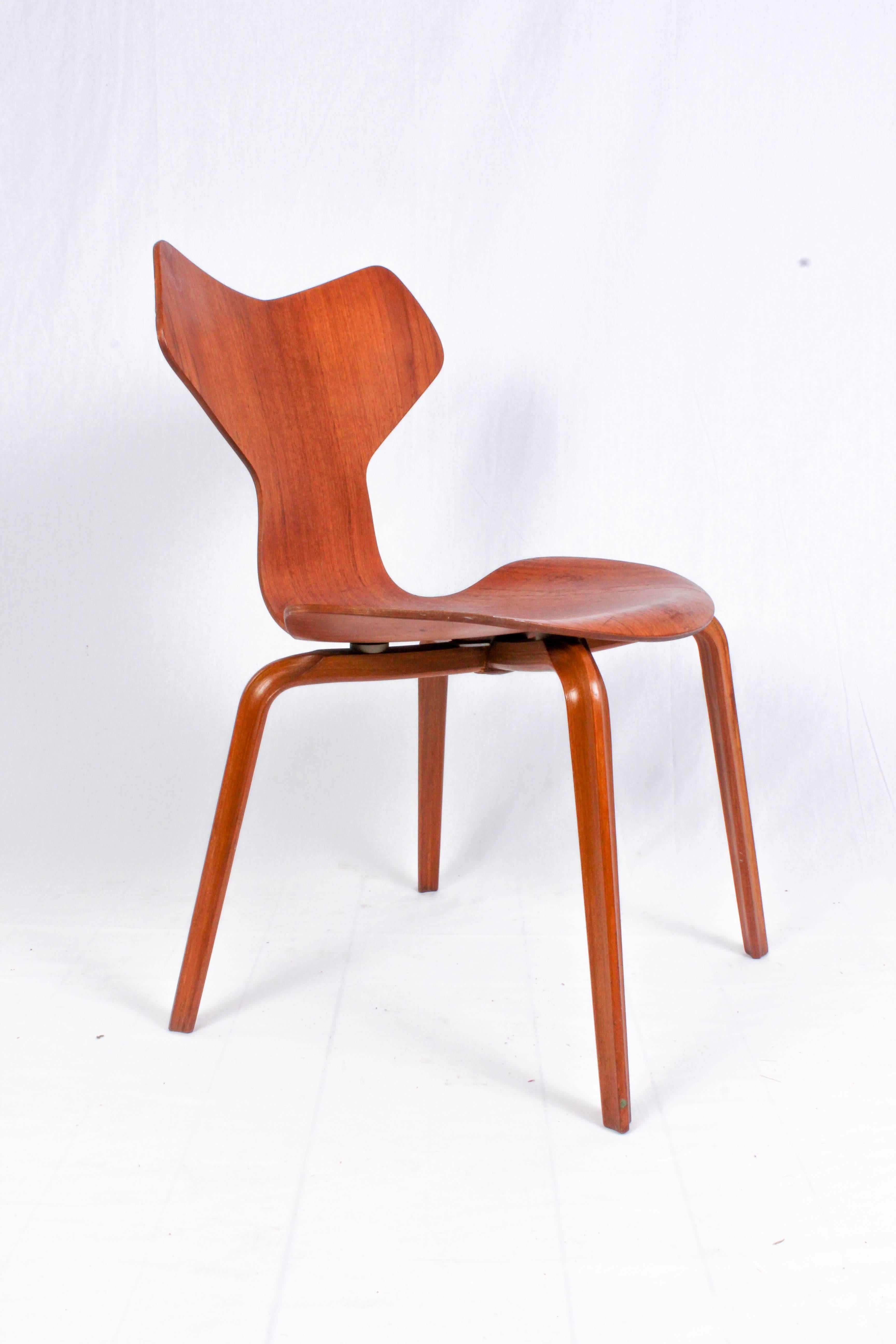 This iconic design Classic was designed by Arne Jacobsen in 1957 and this piece was produced by Fritz Hansen in 1964. The chair is made out of teak and is in good vintage condition with signs of usage consistent with age. 
The model 3130 chair, or