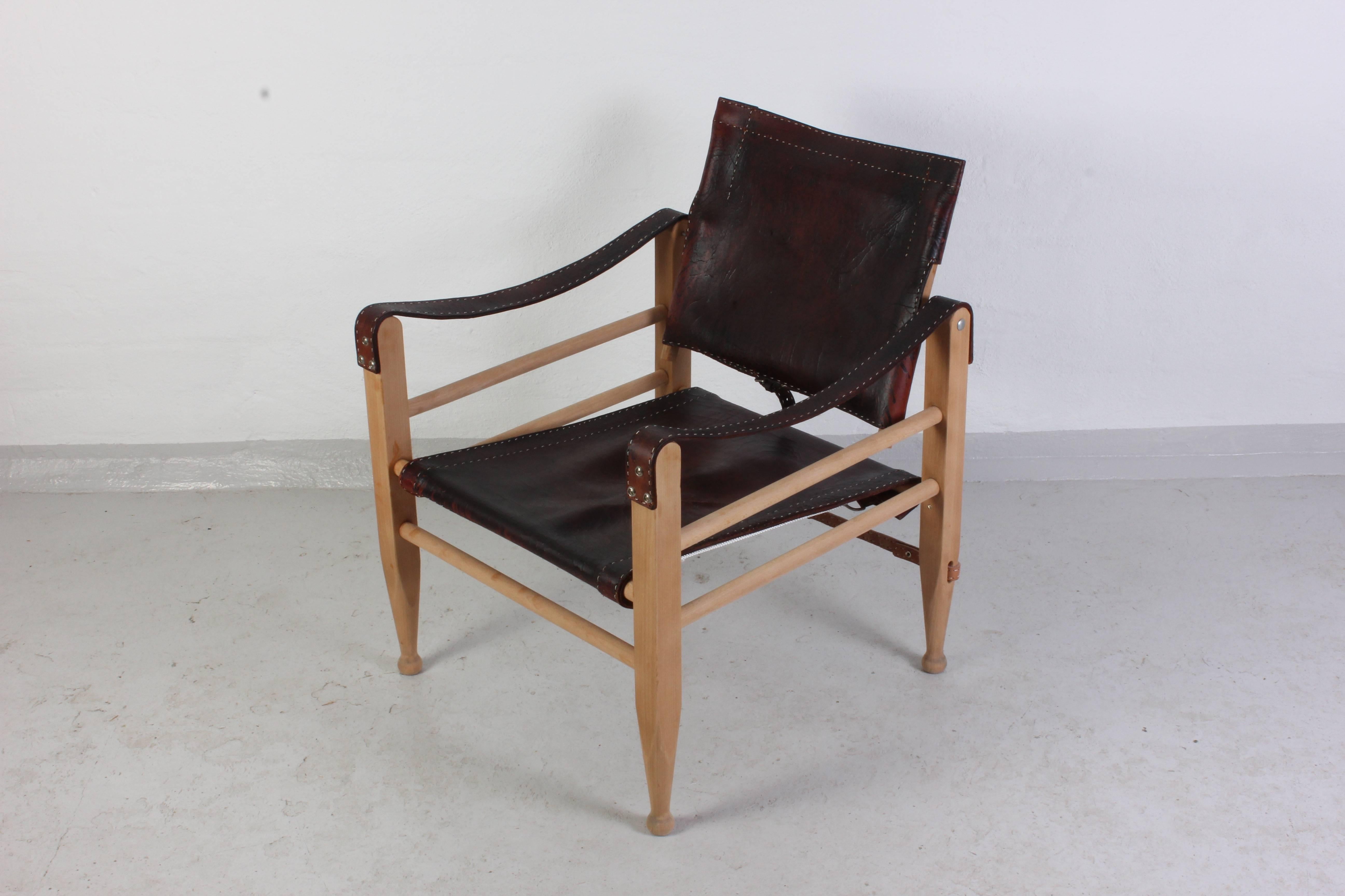 Midcentury safari chair by famous Danish designer Børge Mogensen. This chair has high quality dark brown leather upholstery with lovely hard patina. The lover back strap has been professionally replaced.