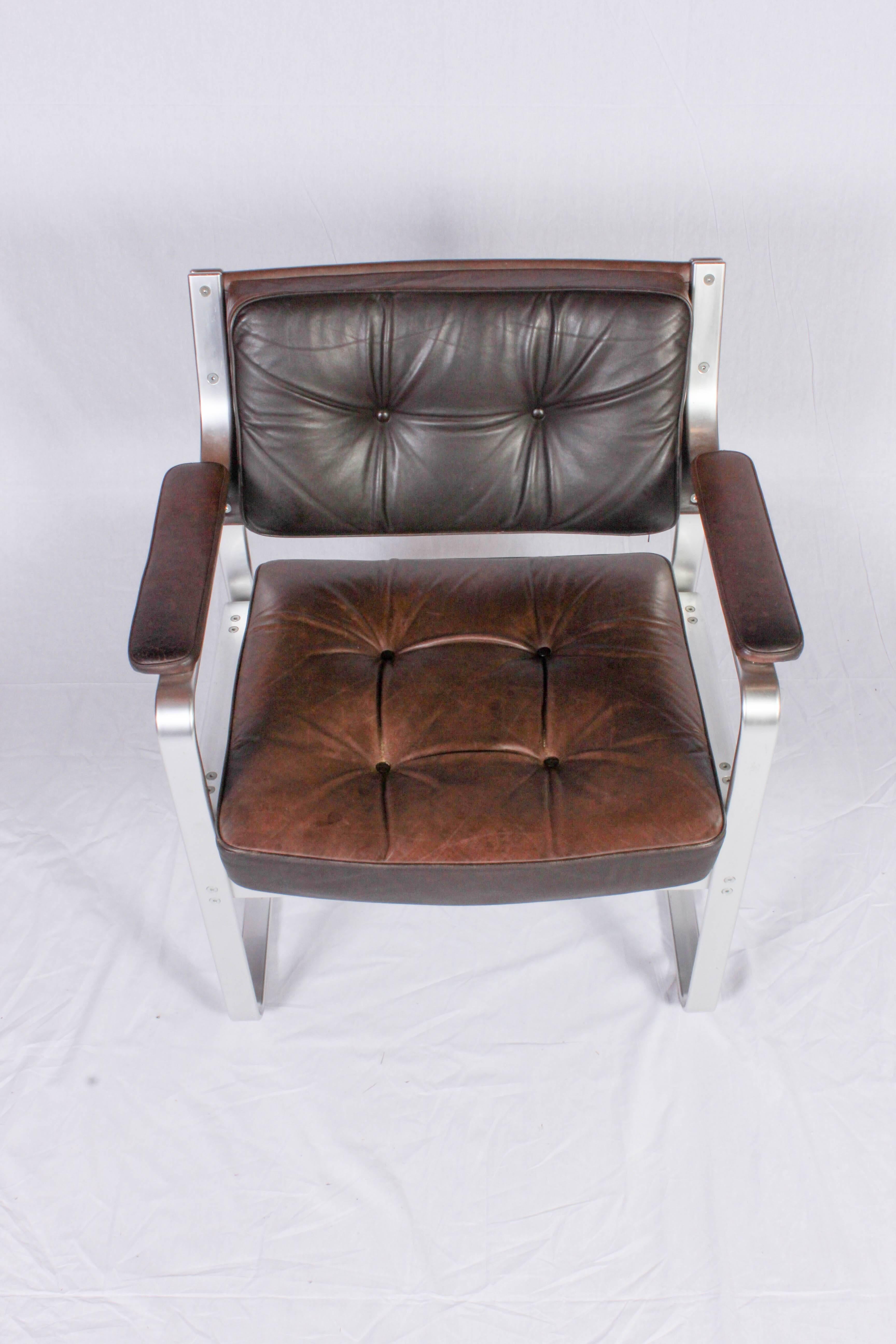 Highly decorative midcentury chair by Swedish designer Karl Erik Ekselius. The chair is made out of aluminum and brown leather with nice patina. The condition is very good with patinated leather and signs of usage consistent with age.