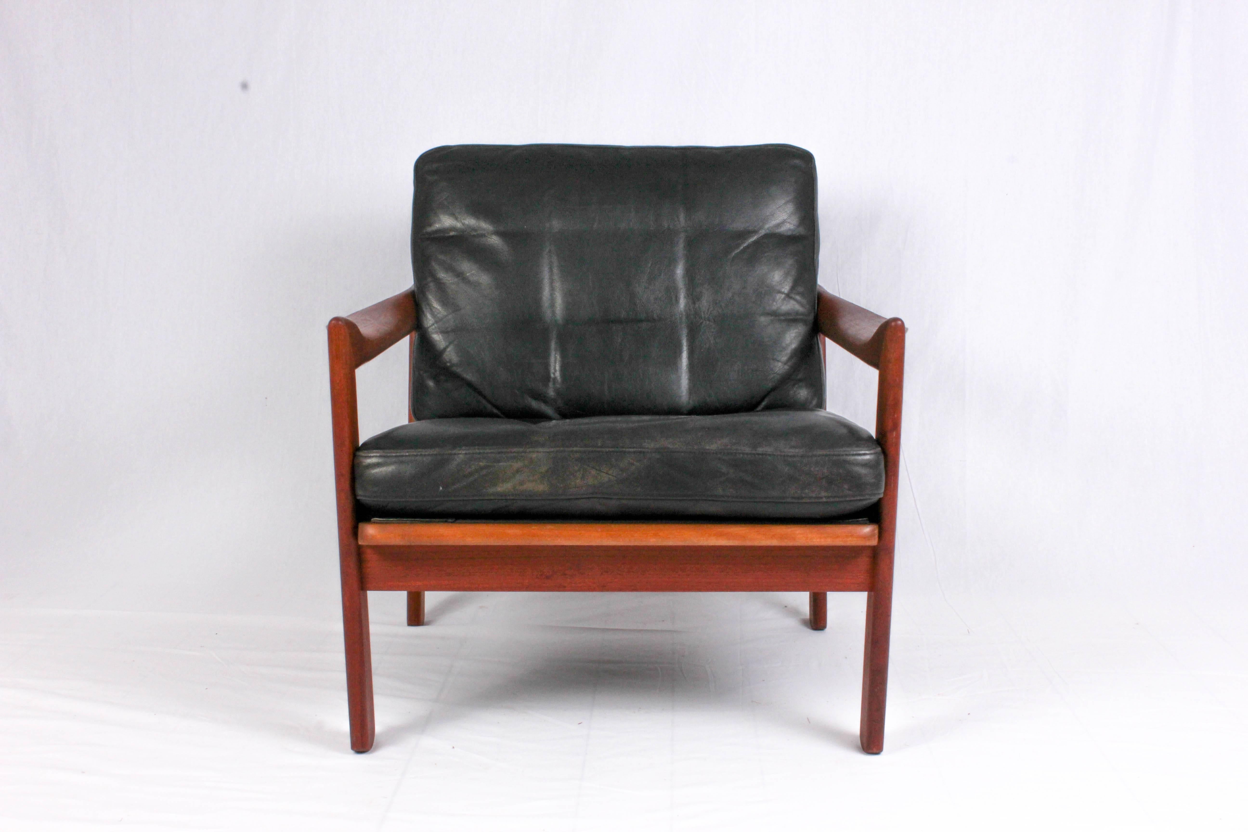 This midcentury teak armchair is designed by Danish designer Illum Wikkelsø and produced by Niels Eilersen. The chair has beautiful twisted armrests and leather upholstery with minor signs of usage and patina. A very decorative and comfortable chair
