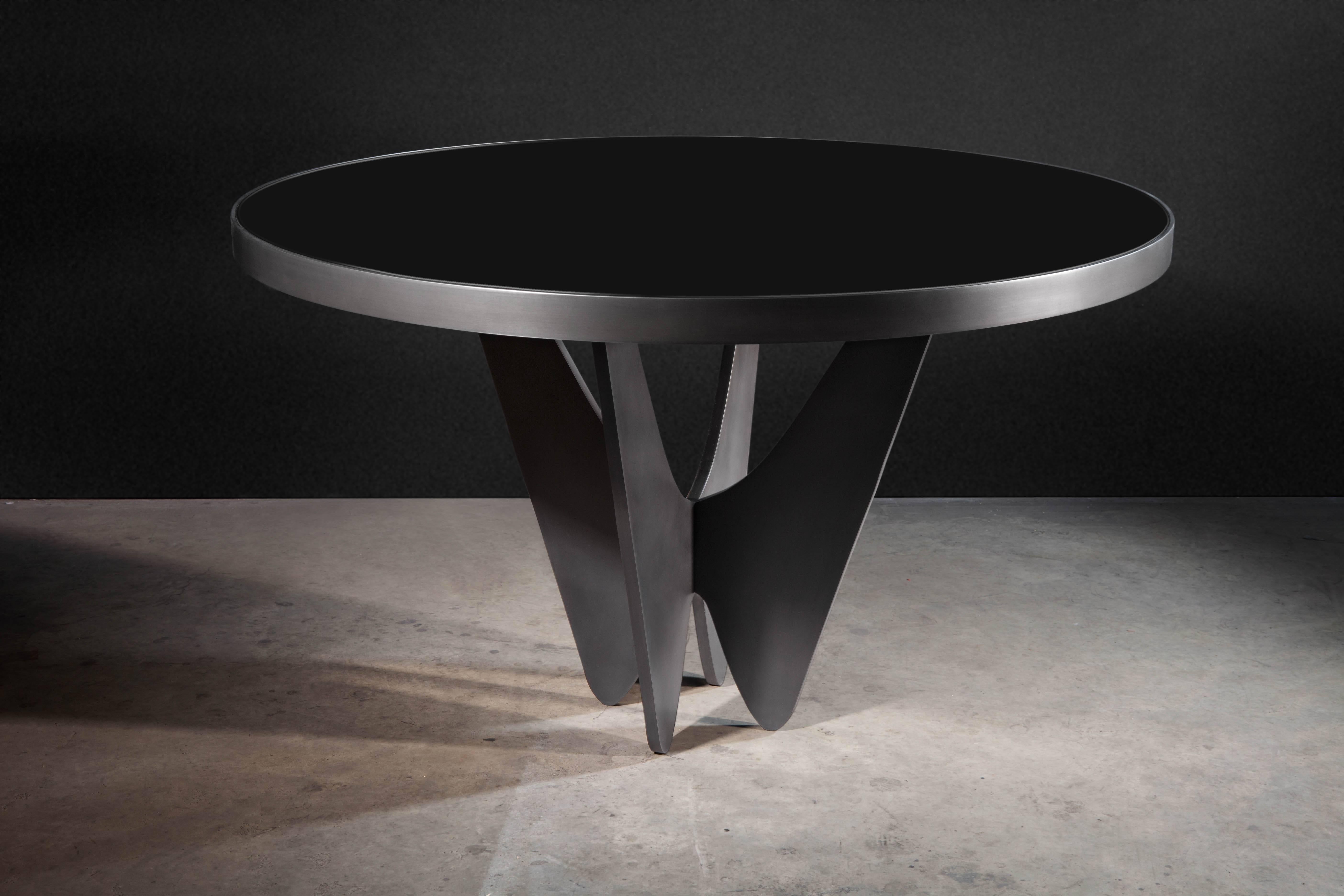 The Papillon Dining Table forms the perfect union between black glass and a dark grey/black metal base. 
Use as an entry foyer table or desk/writing table.

Featured in Architectural Digest and Elle Decor.

Designed by Soraya Osorio.
 
