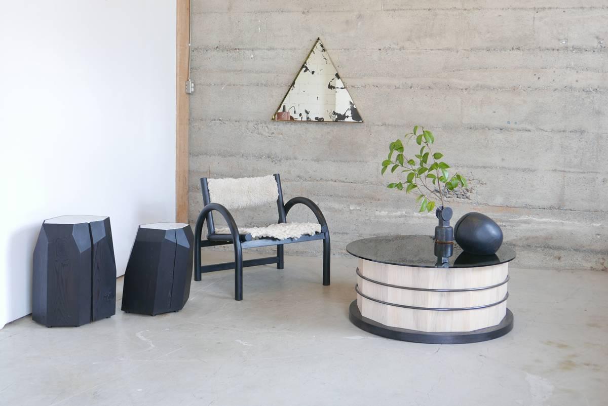 The table is highly customizable. Shown here is whitewashed Canadian white ash with a black dyed base, blackened steel hoops and a smoked glass top. 

This unique contemporary table has floating steel hoops let into a 12-sided stave base, and holds