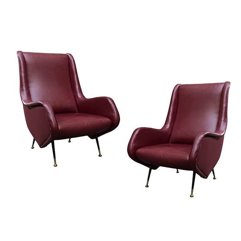 Pair of exquisite armchairs designed by Aldo Morbelli for Isa Bergamo, in the 1950s. Faux leather red fabric. Lacquered metal legs with brass feet.