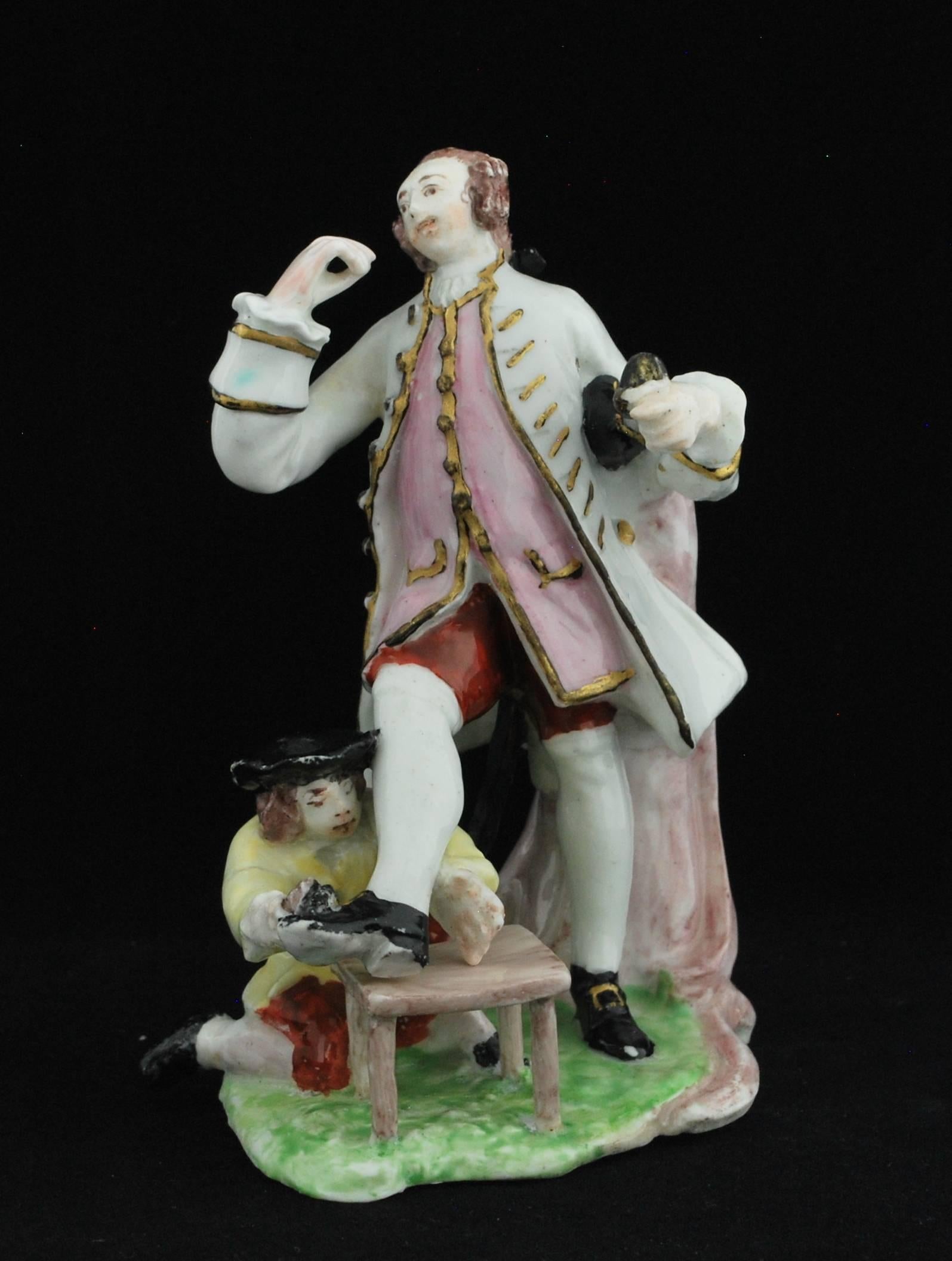 A fashionably dressed gentleman, almost certainly the actor David Garrick: he wears a white frockcoat, pink waistcoat and red breeches, all with embroided gilt enrichments and white stockings, one of which is incised with underglaze decoration. He