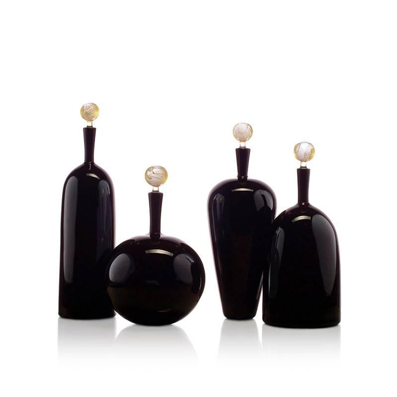 With a 24-karat gold stopper, the Carmella Barware collection is offered in four handsome and elegant blown glass vessel shapes. The high shoulder vessel is a masculine statement of line and form. Each decanter is meticulously mouth blown and