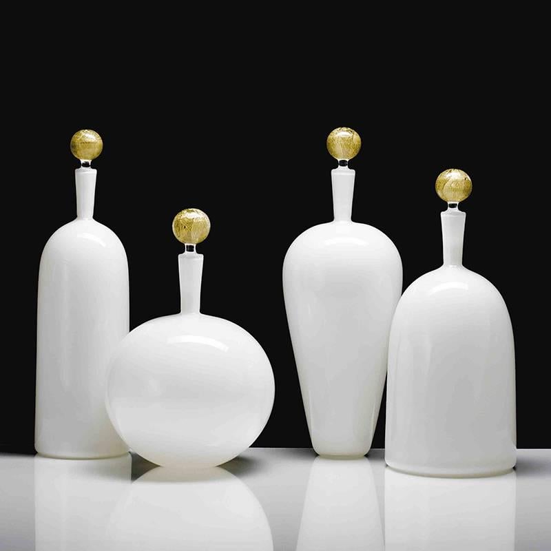 With a 24-karat gold stopper, the Carmella Barware collection is offered in four handsome and elegant blown glass vessel shapes. The low round vessel is a sexy and bold statement and pairs well with the tall bottle or high shoulder Carmella Barware.