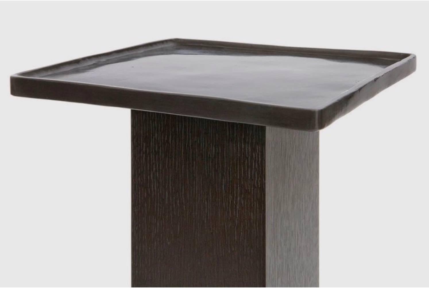 The sturdy rift-sawn oak pedestal supports a functional cast-bronze tray finished with an antiqued patina in this stylish yet sensible accent table. Use it in a living room to display decorative items such as sculptures or busts and plant-filled