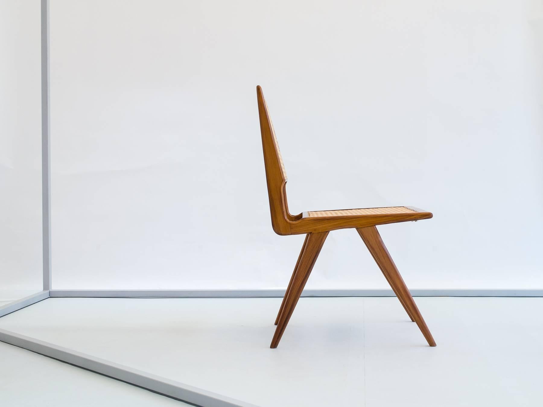 Beautiful chair produced in Brazil by Forma S/A, circa 1956. This rare version has a caned seat and back, while the more common versions have a padded seat. Shows remains of the factory paper stamp inside the front stretcher.