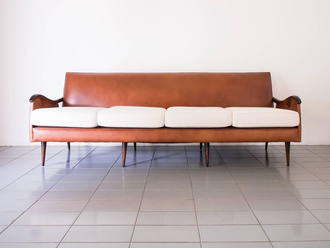 Big and classy four-seat sofa, with arms and legs in Brazilian rosewood, produced by Liceu de Artes e Ofícios, São Paulo, Brazil, 1950s. Beautiful rosewood piece runs through the whole back of the sofa.