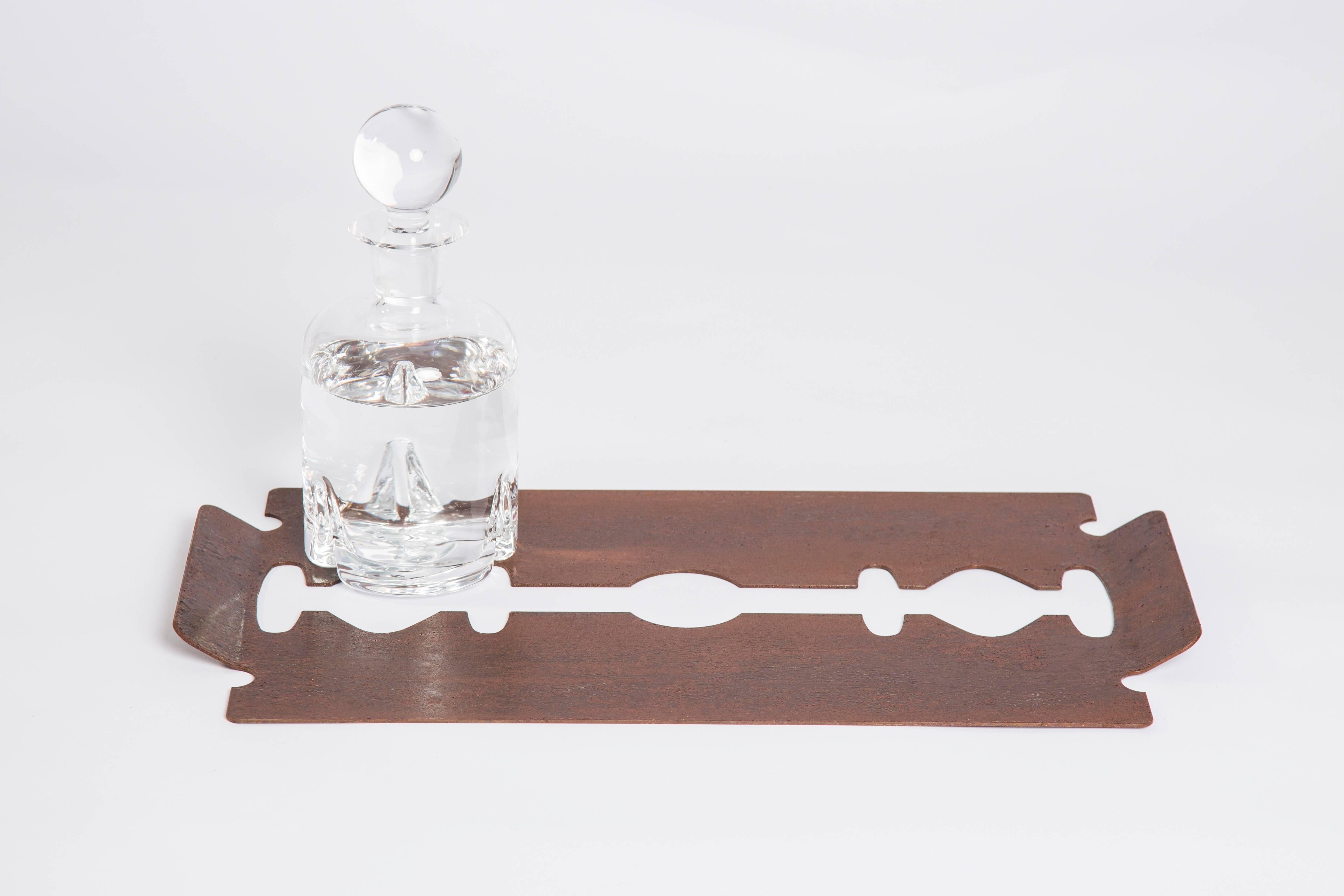 This cocktail tray with rust-colored plating is made to resemble the blade of a razor, a playful proposal of the designer. Topcoat in rusty plating, minimalist and modern style.